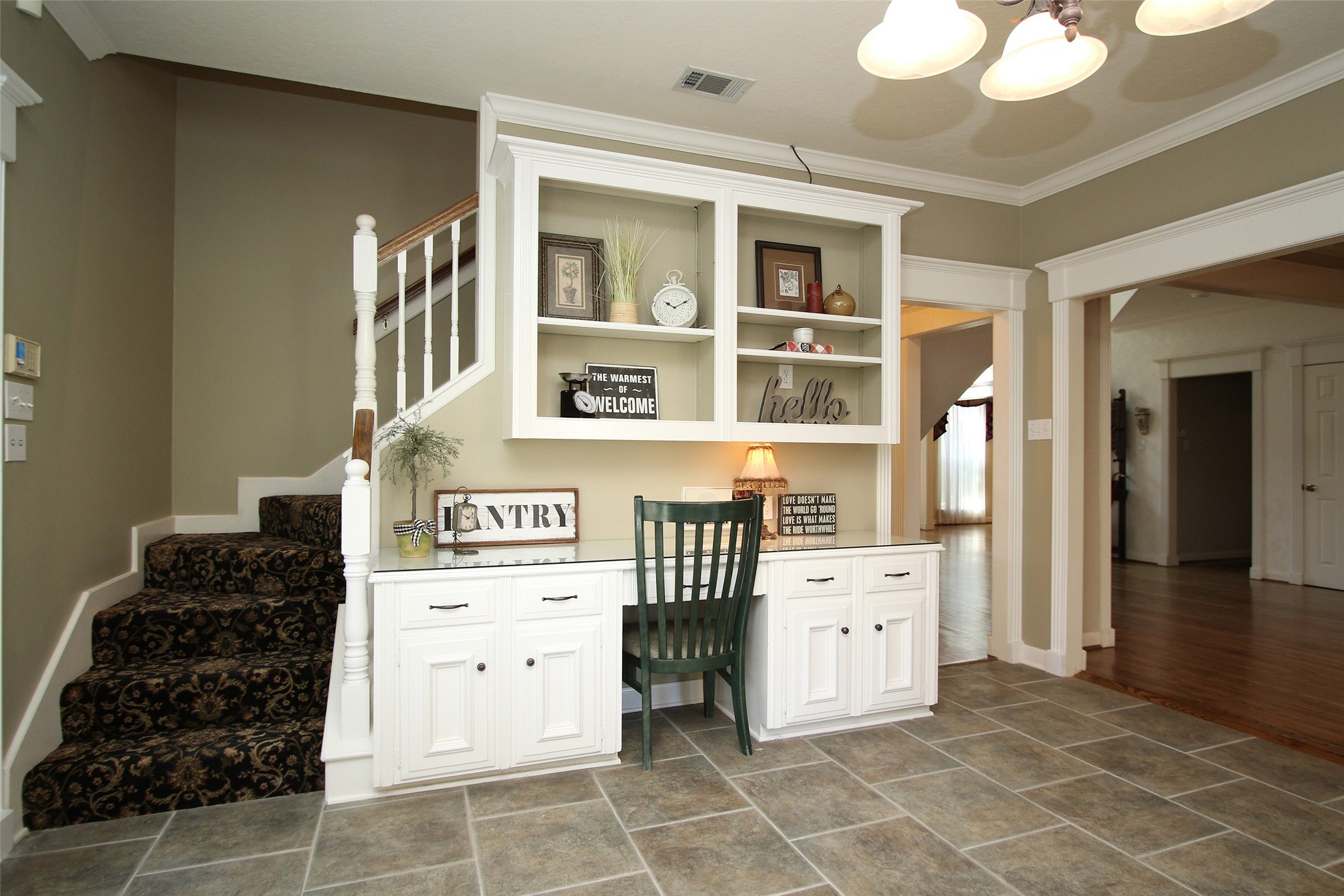 BUILT IN DESK AREA IS CONVENIENTLY LOCATED IN THE KITCHEN WITH THE SECOND STAIRCASE TO THE LEFT, LEADING UPSTAIRS TO 4 BEDROOMS, 2 OTHER FULL SIZE BATHS AND A LARGE GAME ROOM.