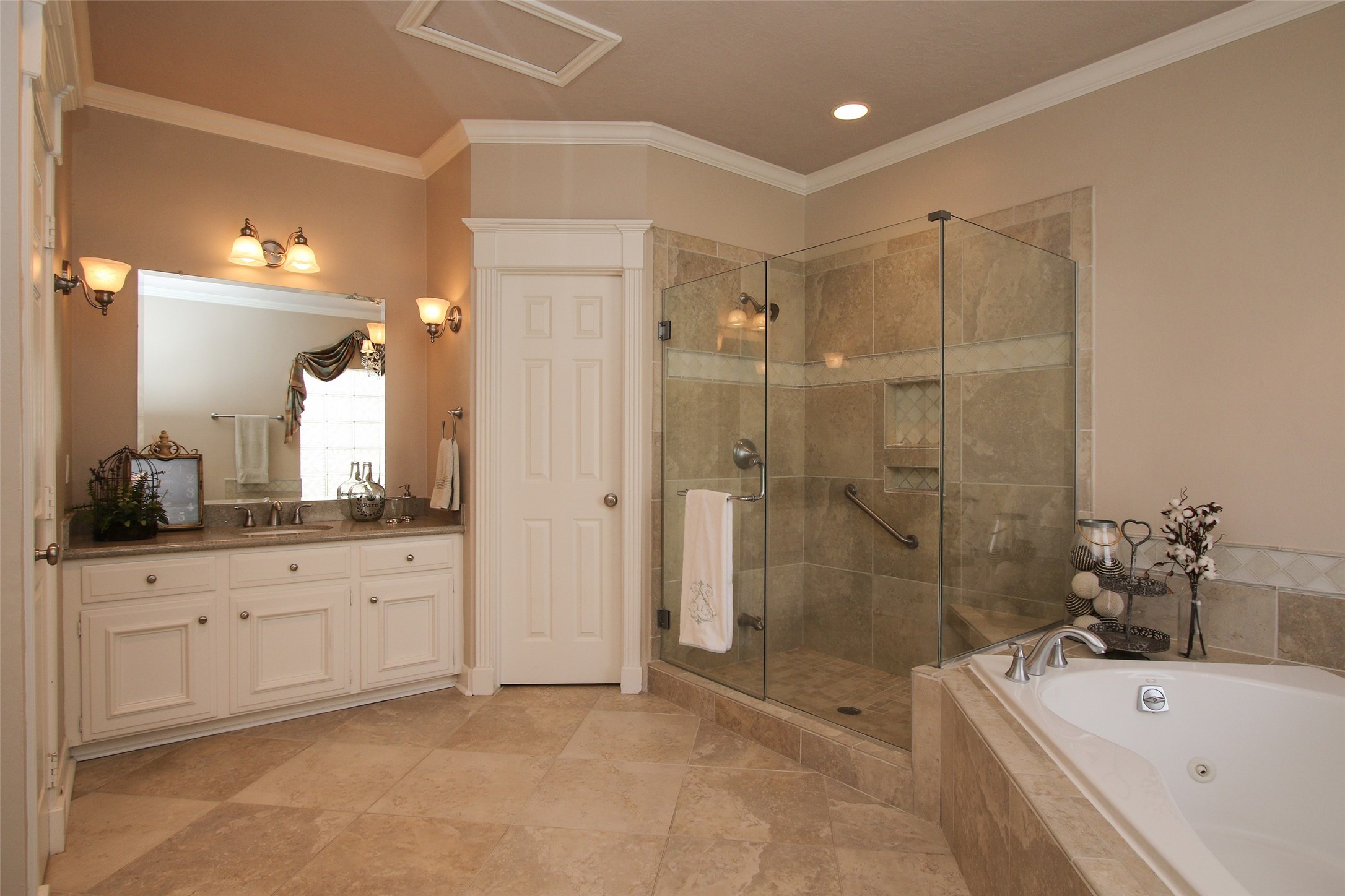 MASTER BATHROOM WITH DUAL GRANITE VANITIES AND TWO LARGE WALK IN CLOSETS.  This view of the Bathroom shows the Second Vanity.  The other Vanity has a sitting space.  The large window that is over the tub (as seen in the mirror) brings in great natural light.  Large Walk in shower with frameless glass enclosure and new Silver Nickle Faucets.