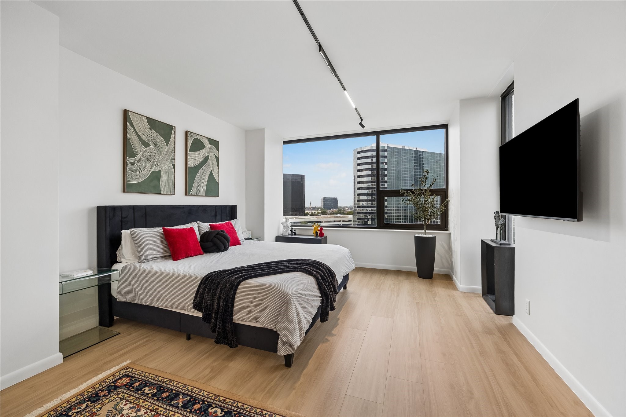 Dedicated smart thermostat serves the primary bedroom, where a broad window frames city views.