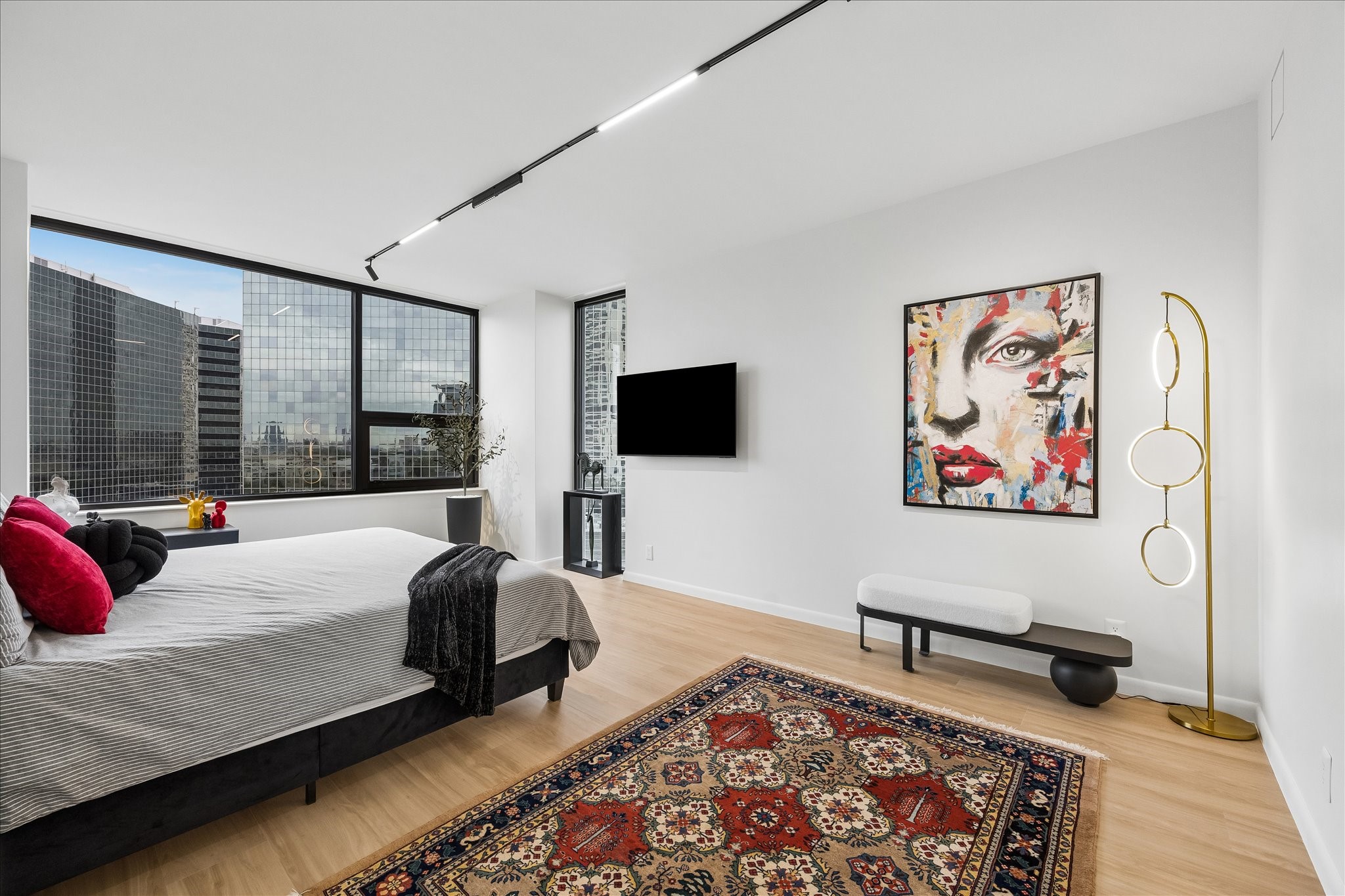 Windows on two sides bring natural light and city views into the primary bedroom. Windows on two sides bring natural light and city views into the primary bedroom.