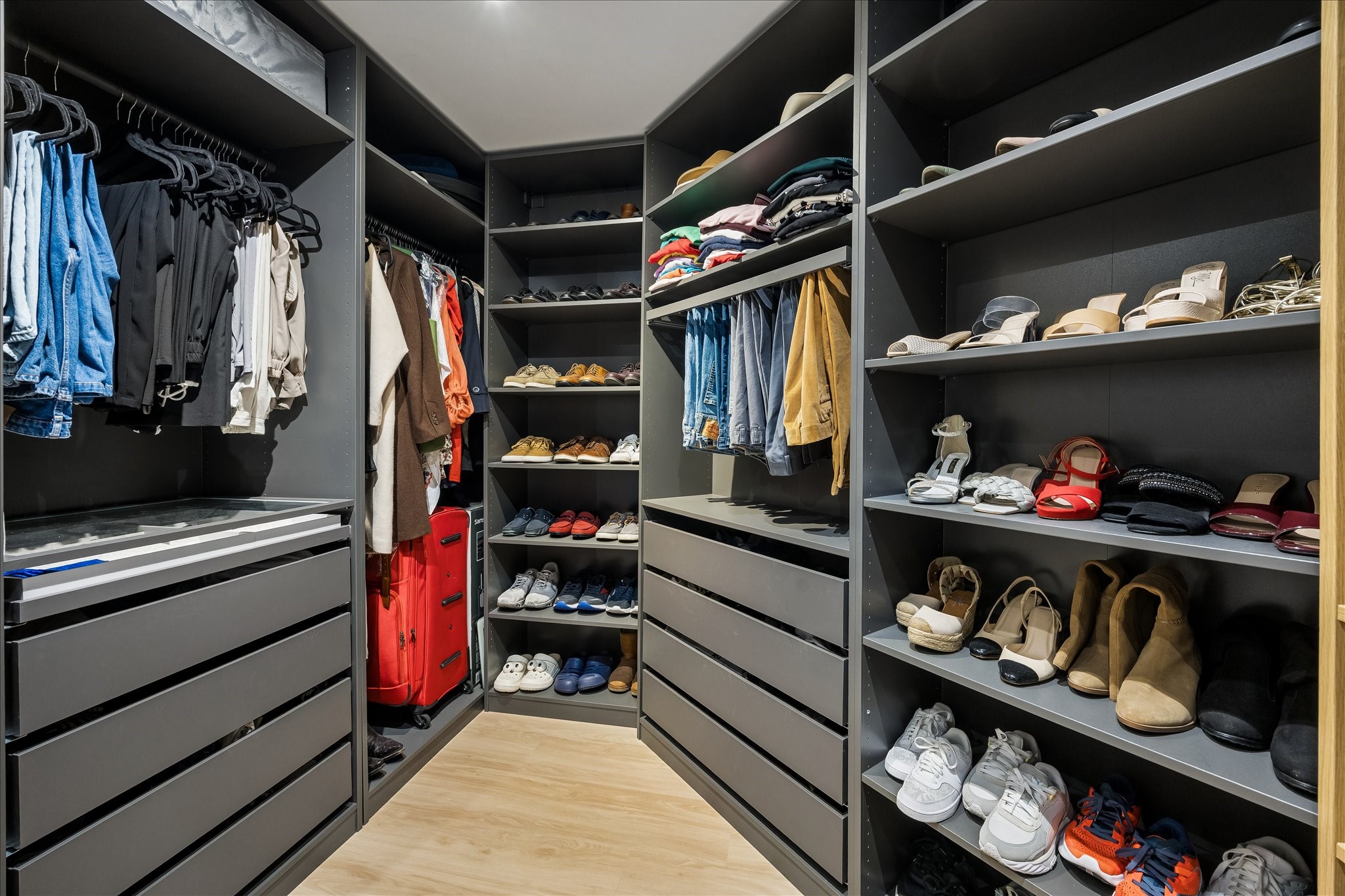 Open shelves, drawers and hanging rails show the closet's storage capacity from the opposite side.
