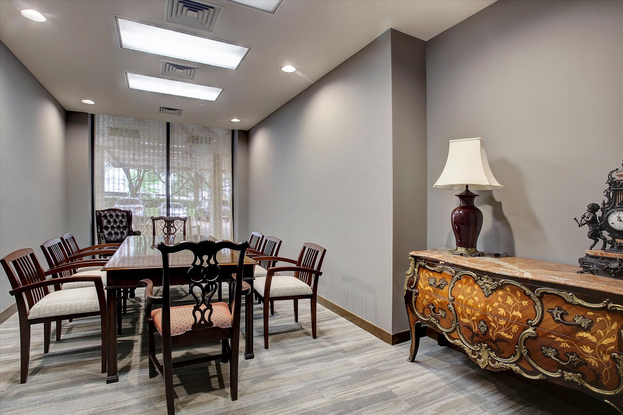 The buildings conference room provides a separate space for resident meetings, featuring a long table, ample seating and natural light at the far end of the room.