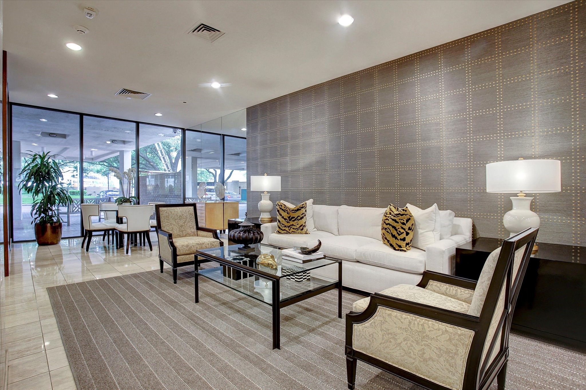 An additional view of the lobby highlights its generous seating arrangement, textured accent wall and natural light from the surrounding windows.
