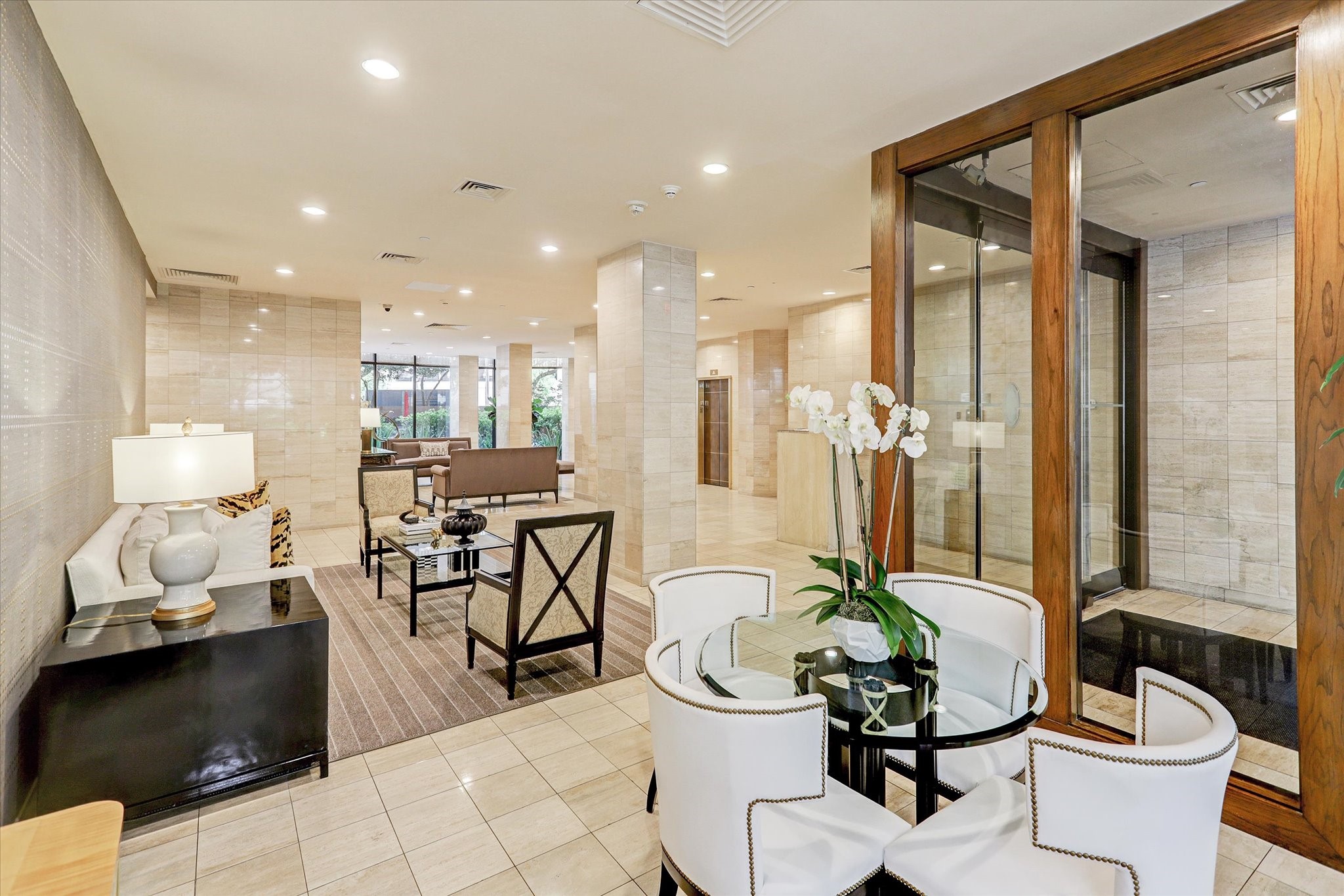 Multiple seating areas extend through the lobby, where wood-framed glass doors, coordinated furnishings and warm finishes create a polished setting for everyday arrivals.