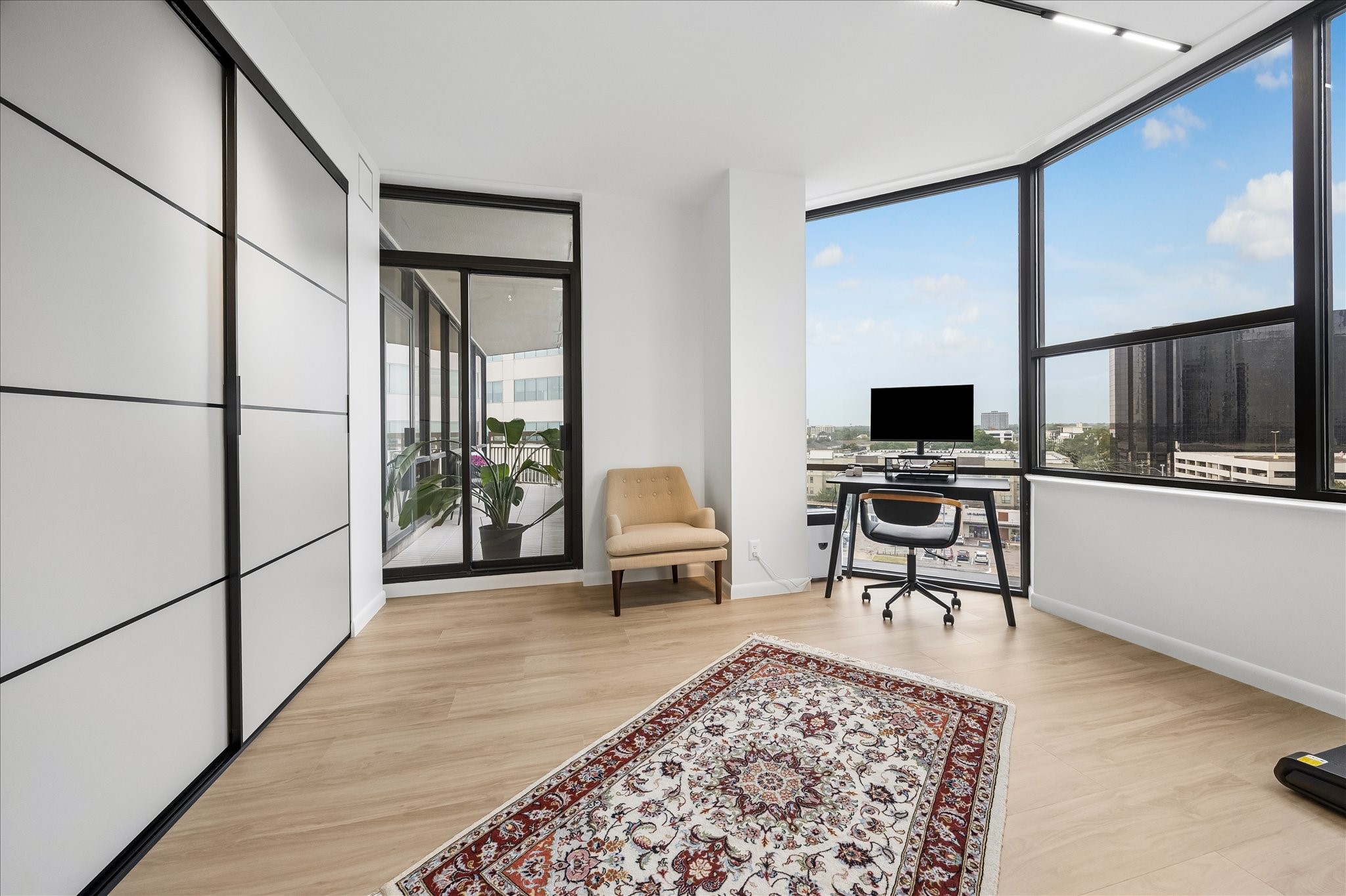 Sliding closet doors and a balcony entrance add storage and outdoor access to the flexible bedroom.
