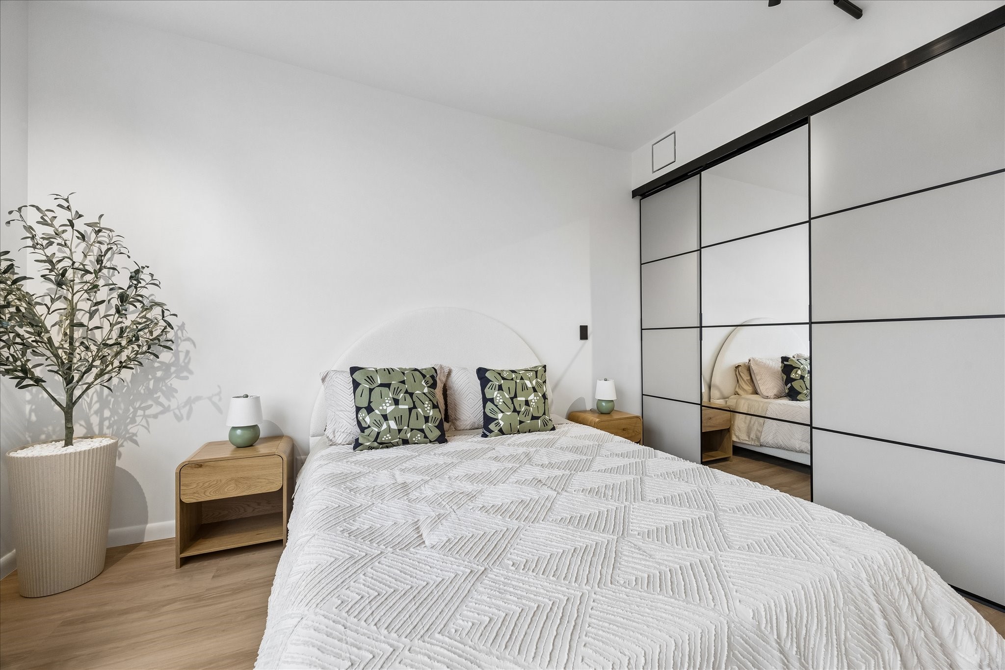 Sliding closet doors provide storage access beside a mirrored panel.