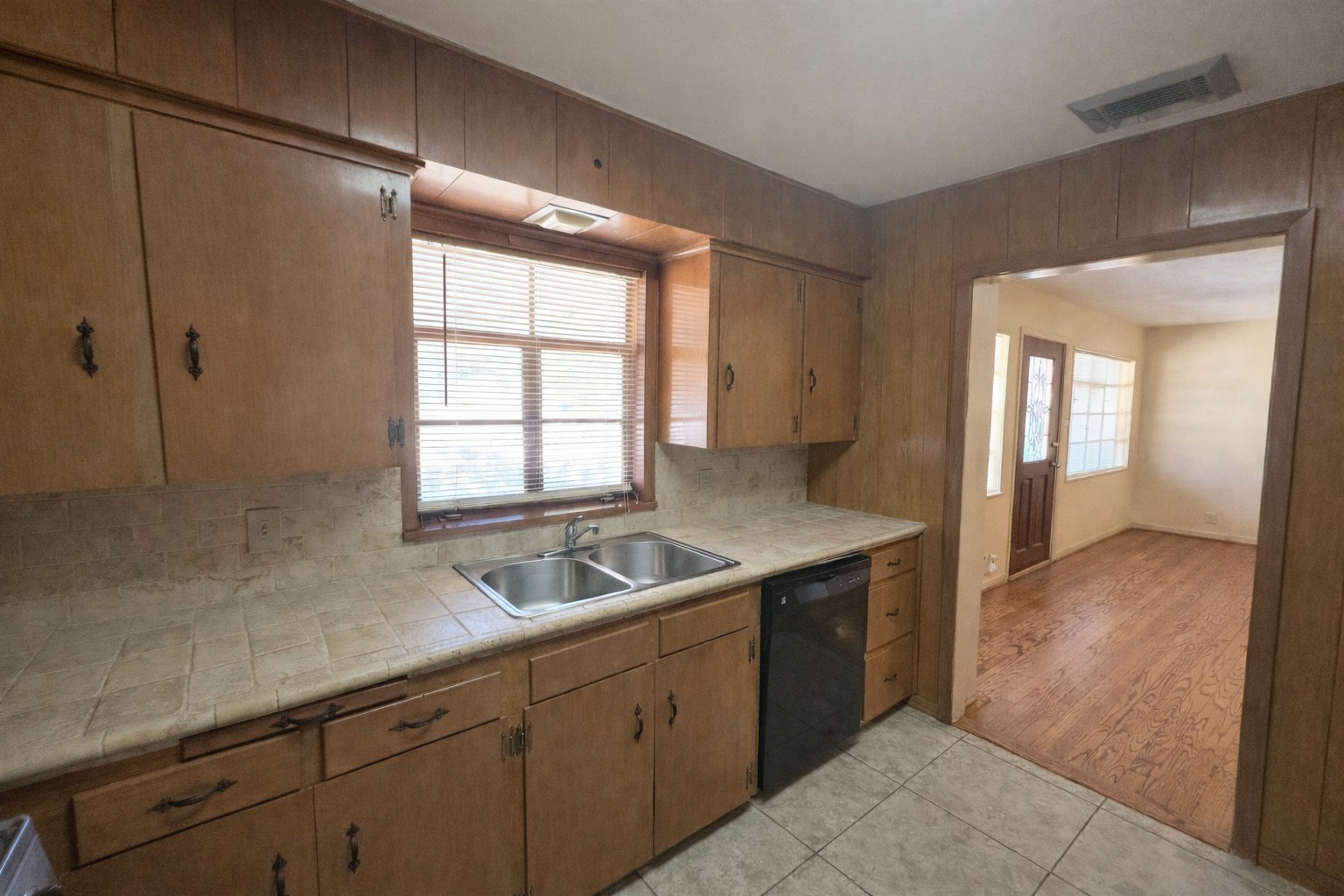 Another view of kitchen. Neutral-colored ceramic tile counter tops and backsplash. Window provides natural light and tile flooring for easy maintenance. Another view of kitchen. Neutral-colored ceramic tile counter tops and backsplash. Window provides natural light and tile flooring for easy maintenance.