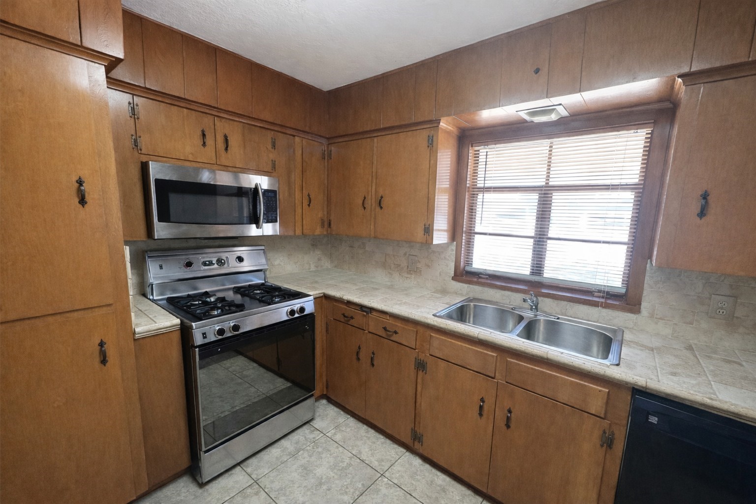 Kitchen with stainless gas range/4-burner cooktop, microwave, dishwasher, and stainless double-bowl sink. Kitchen with stainless gas range/4-burner cooktop, microwave, dishwasher, and stainless double-bowl sink.