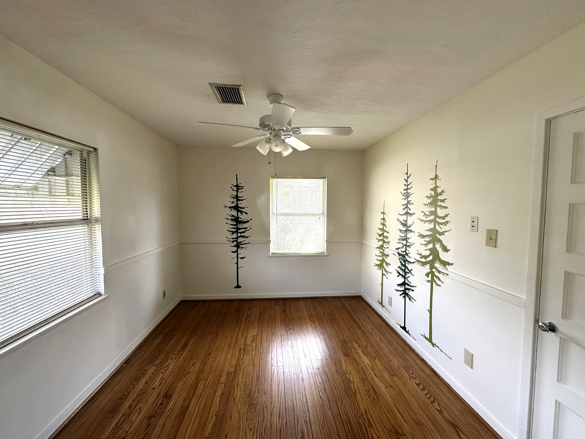 Bedroom #2 is on front corner of home.  Great windows for natural light, ceiling fan and beautiful hardwood floors.