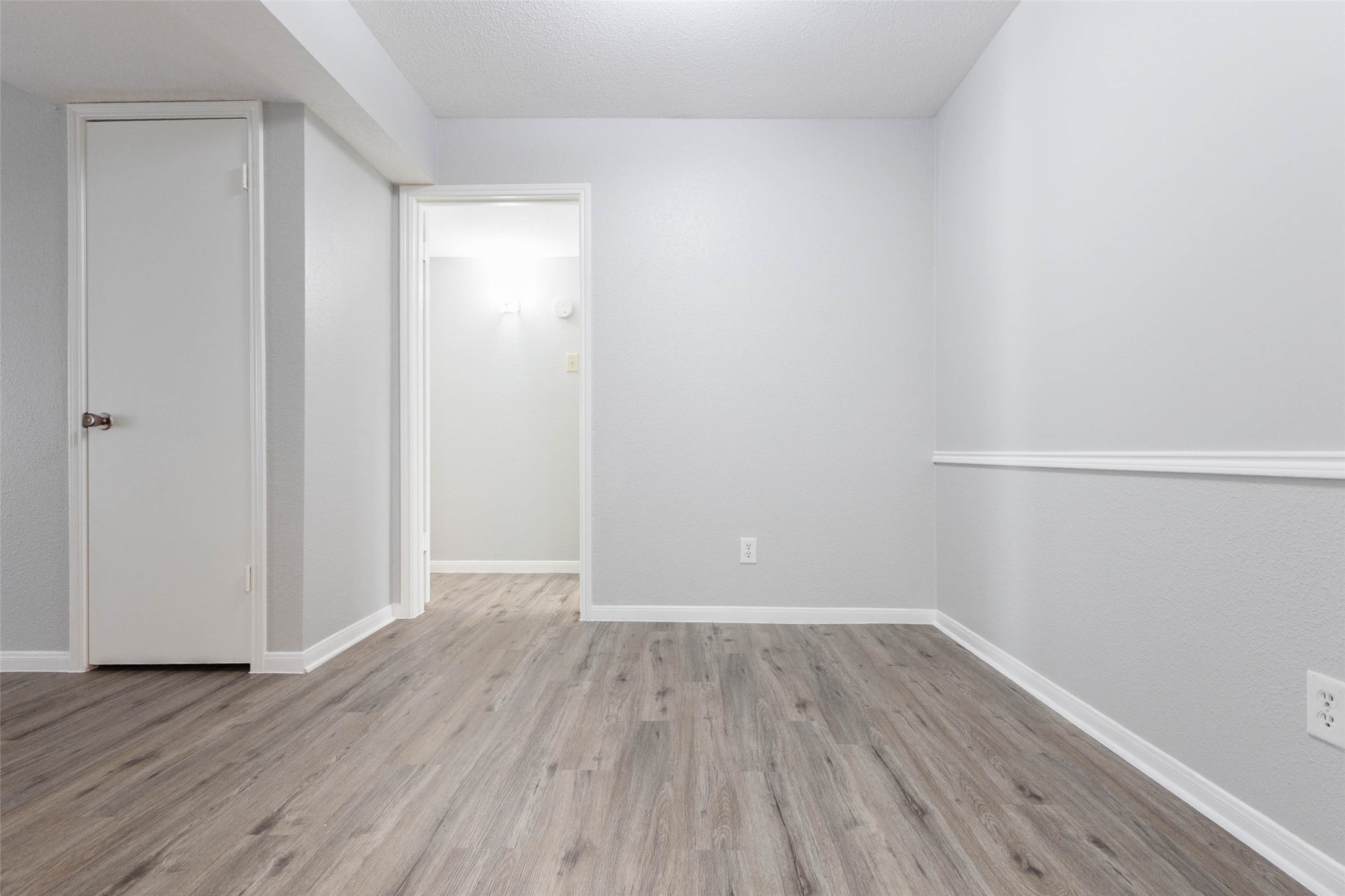 Flexible dining area with wood-look flooring, chair rail detailing, and easy access to the adjoining living spaces.