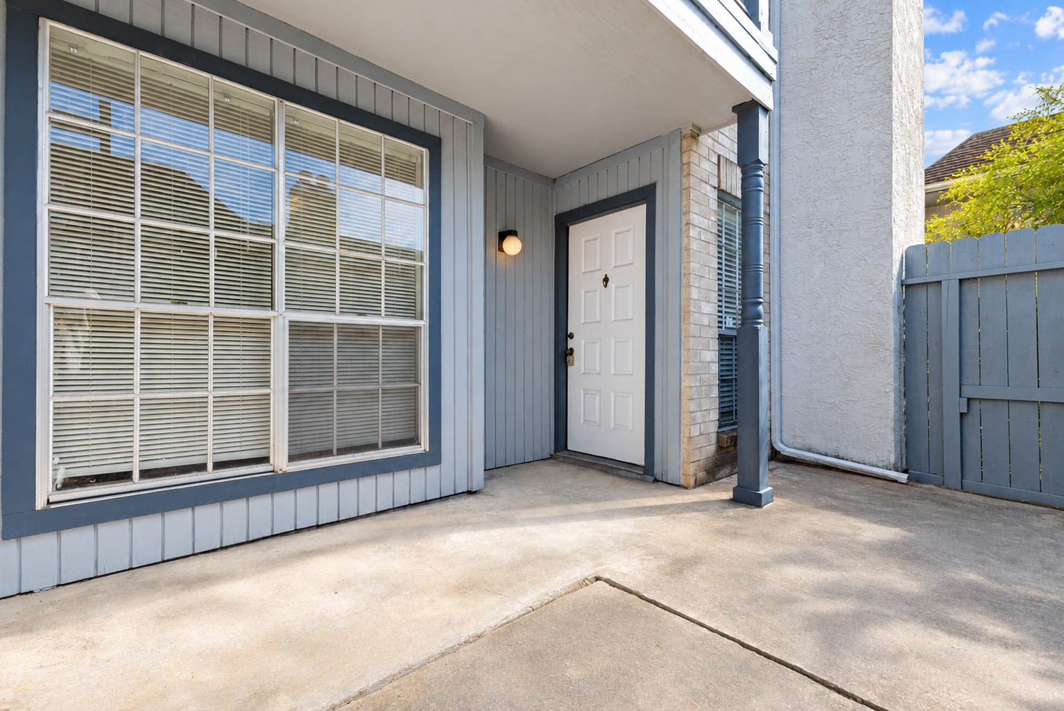 Private enclosed patio with concrete flooring, offering a convenient outdoor space for relaxing or enjoying fresh air.