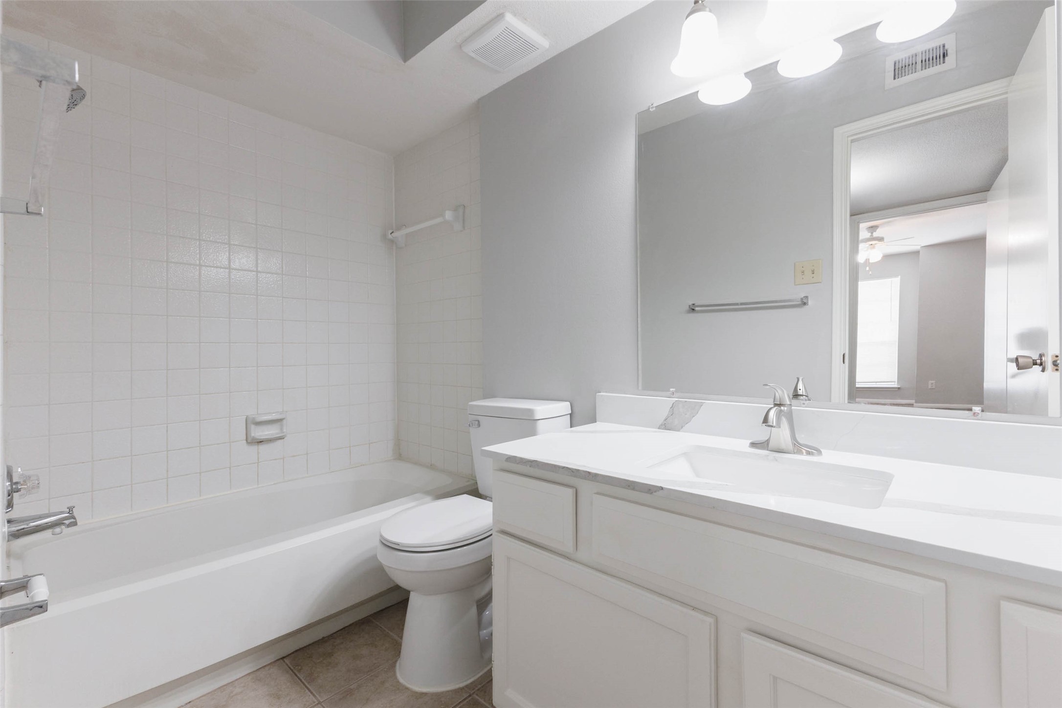 Full bathroom featuring a vanity with cabinet storage, large mirror, and tub/shower combination.