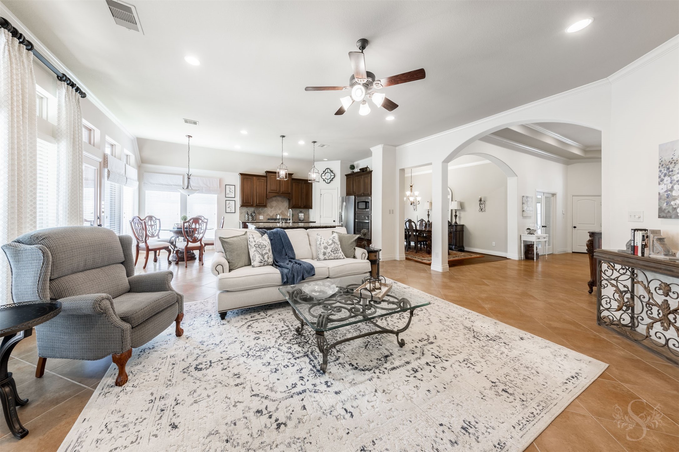 The generous family room anchors an open concept floor plan that brings the kitchen and breakfast room together for effortless entertaining. Expansive windows, elegant crown molding and graceful archways give this beautiful gathering space its bright, welcoming character.