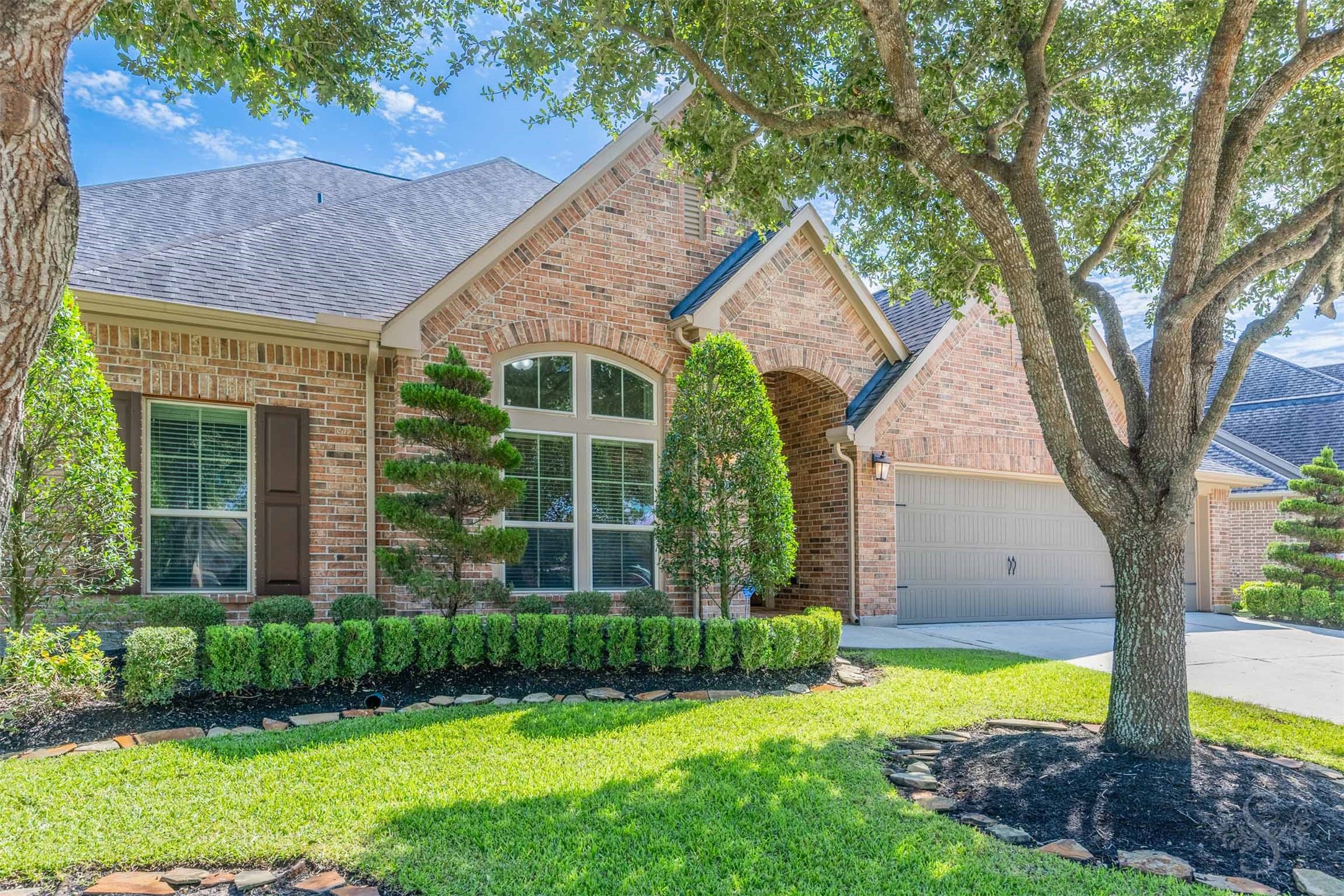 Graceful rooflines & intricate brick detailing give this Perry home an impressive presence along the tree-lined street. Sculpted evergreens & neatly bordered garden beds complement the classic architecture, creating an elegant welcome.
