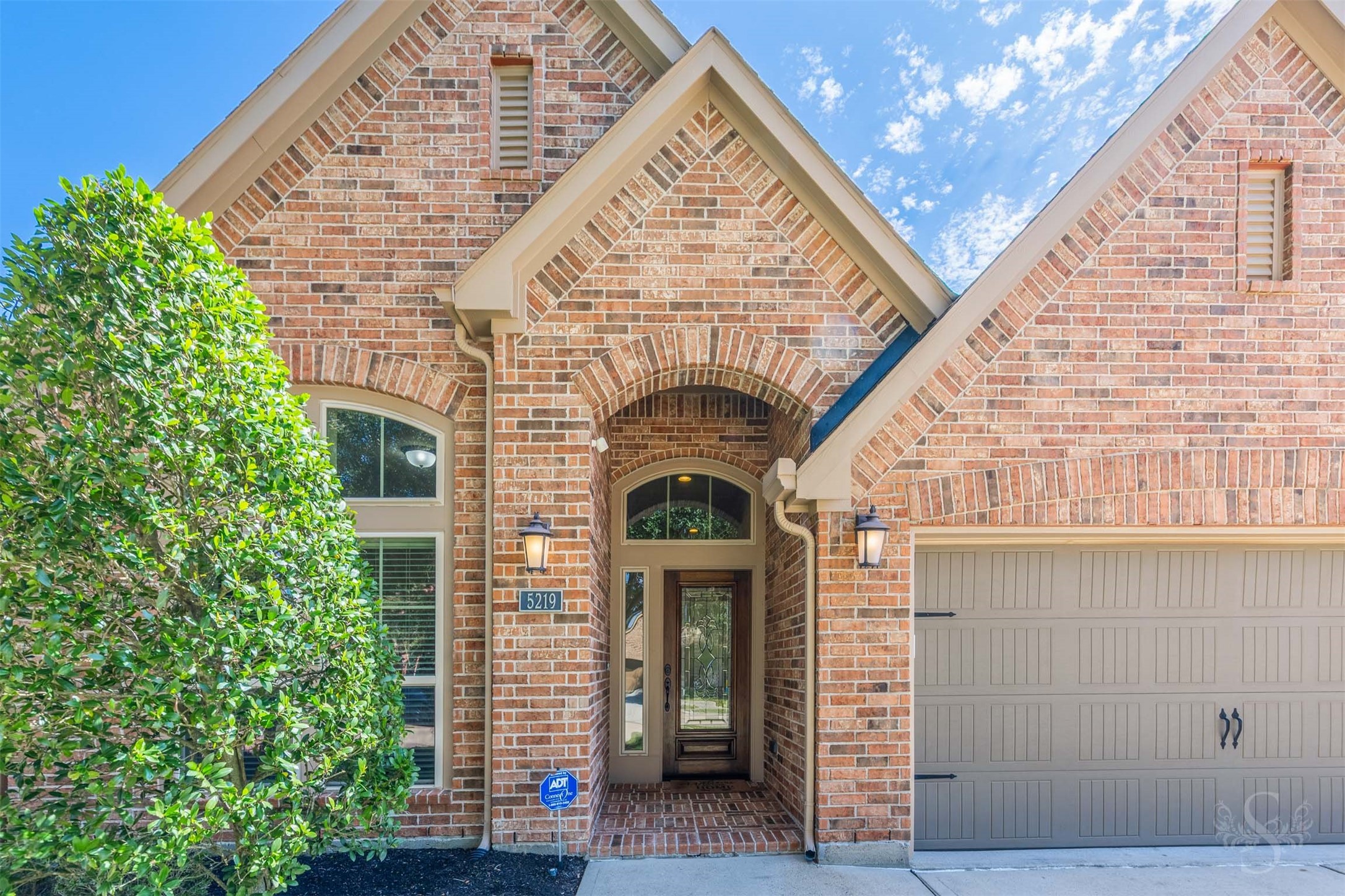 A dramatic brick arch frames the sheltered entrance, where a decorative glass front door, coordinating sidelight & arched transom create an elegant introduction. The brick porch welcomes you inside to an inviting entry crowned by tray ceilings.