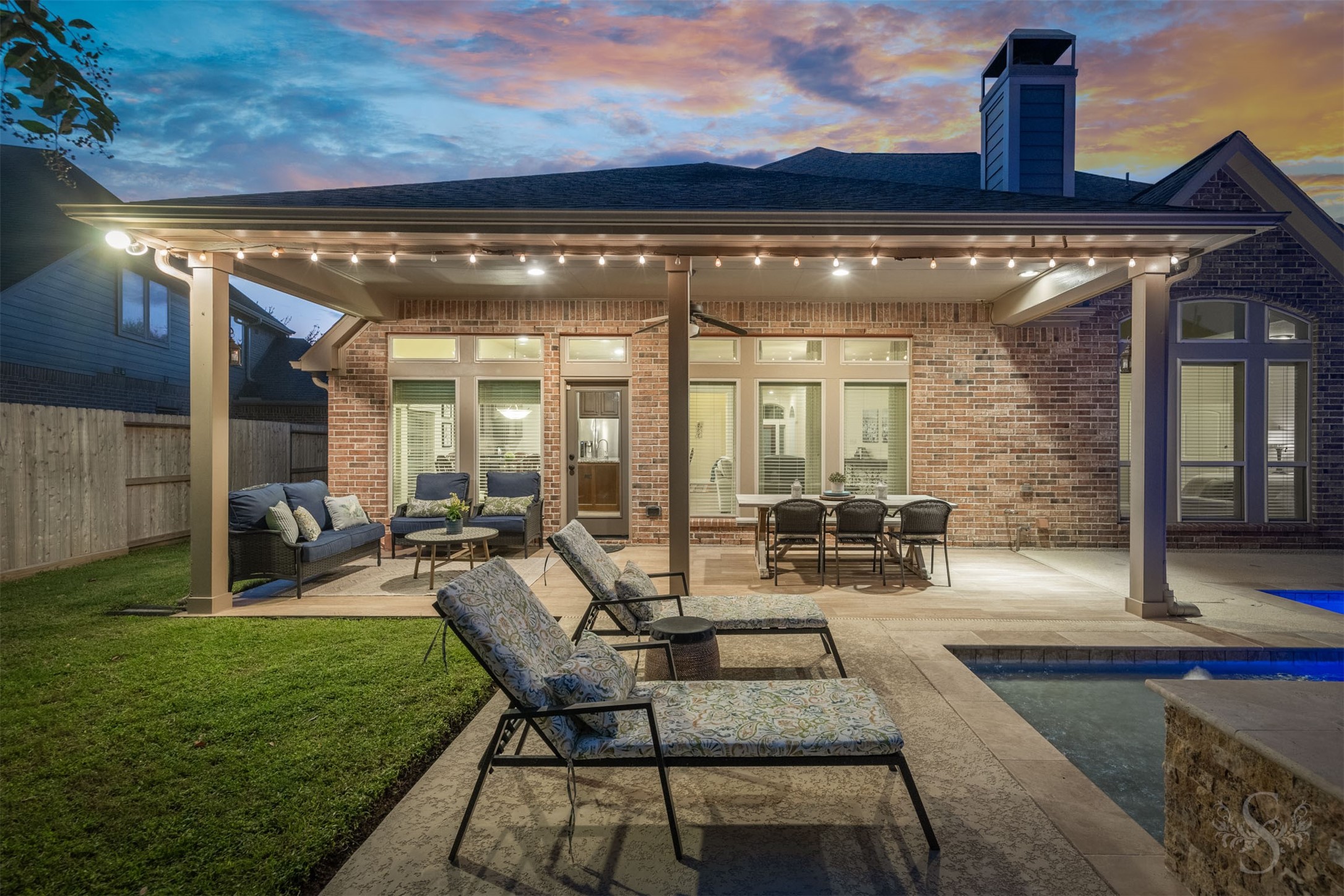 The covered patio creates a luxurious outdoor gathering space with generous room for lounging and dining beside the pool. Enjoy leisurely dinners and relaxed conversation as the evening unfolds in this beautifully appointed backyard retreat.