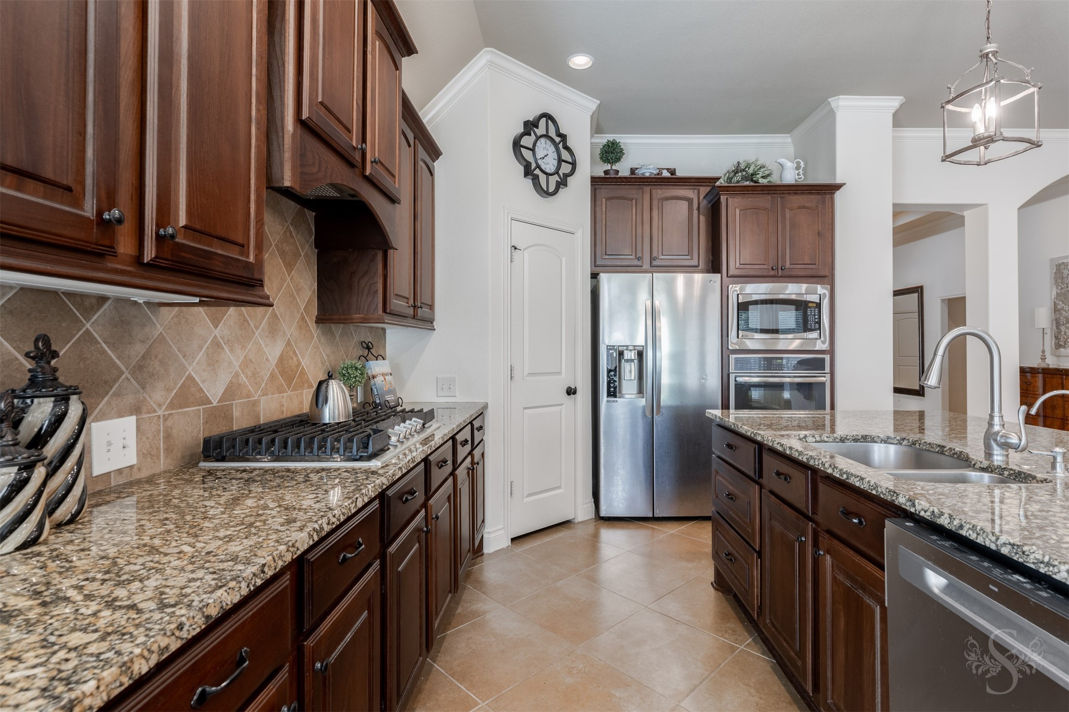 Richly stained 42-inch raised panel cabinetry and polished granite countertops bring timeless elegance to the spacious kitchen. A gas cooktop, built-in stainless steel oven and microwave, and generous island workspace make preparing family favorites and entertaining a pleasure.