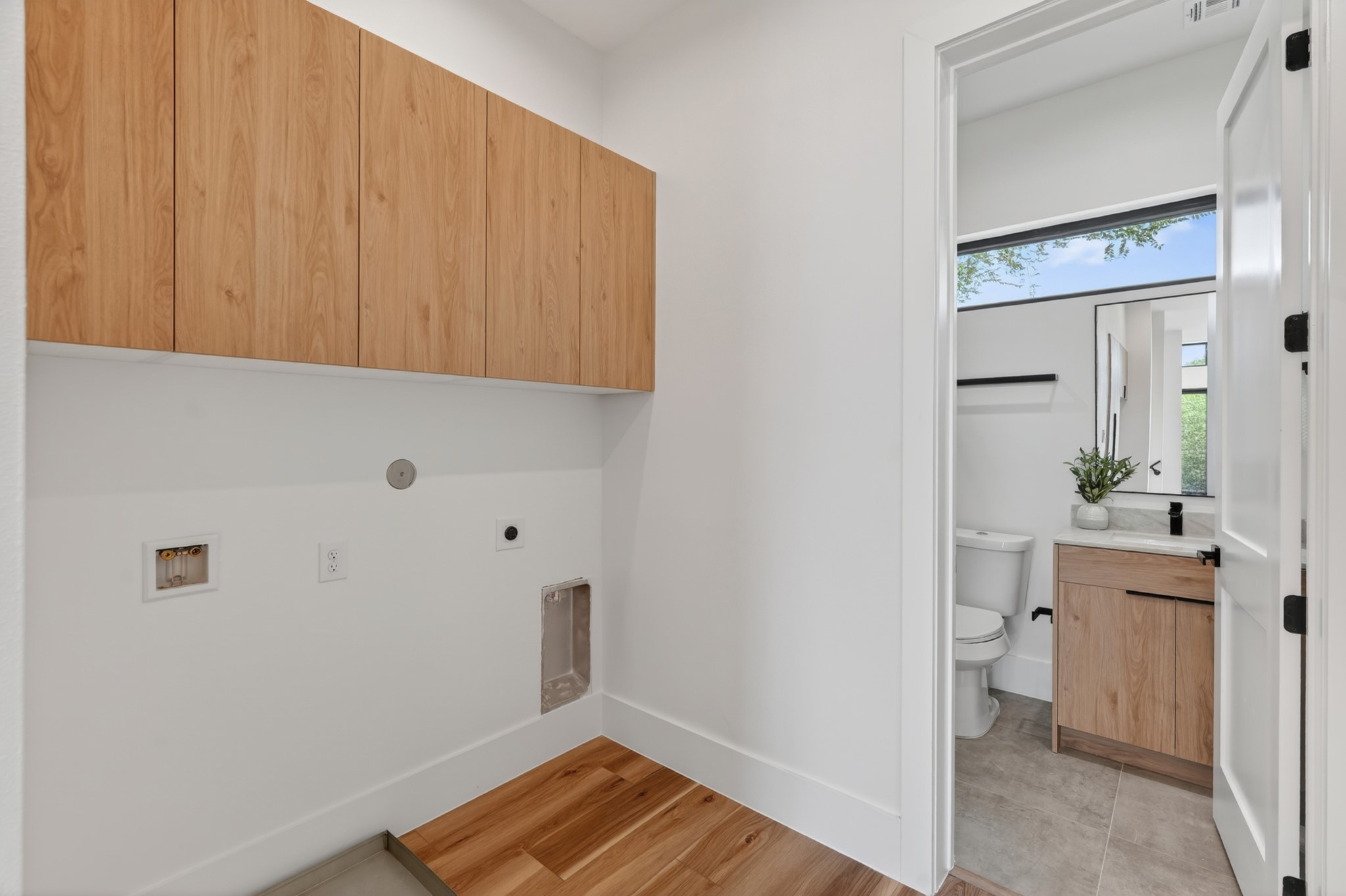 Functional laundry room featuring ample cabinet storage to keep everyday essentials organized and out of sight.