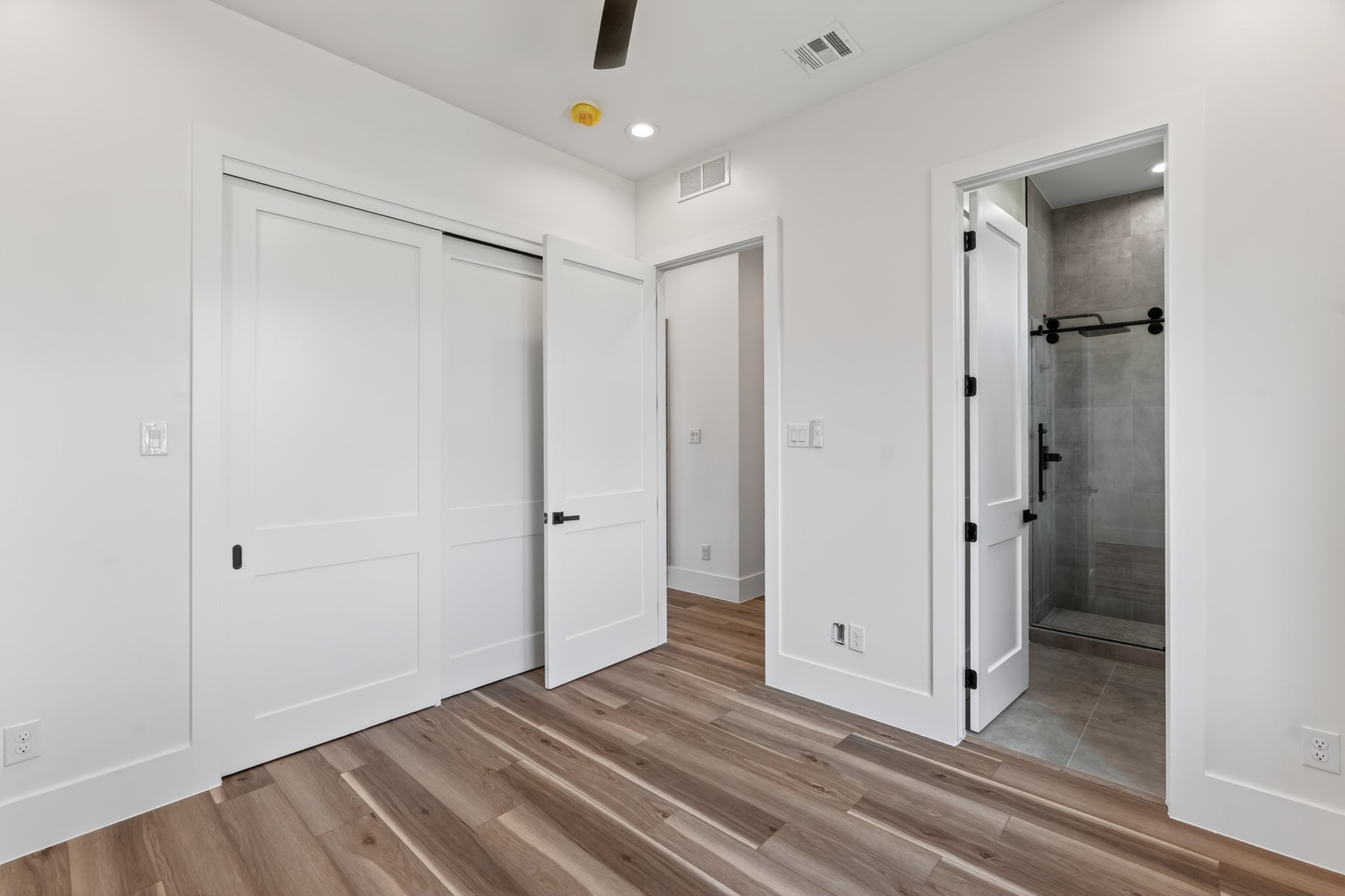 Bright and versatile guest suite featuring abundant natural light, generous closet space, and a flexible layout ideal as a guest bedroom or home office.
