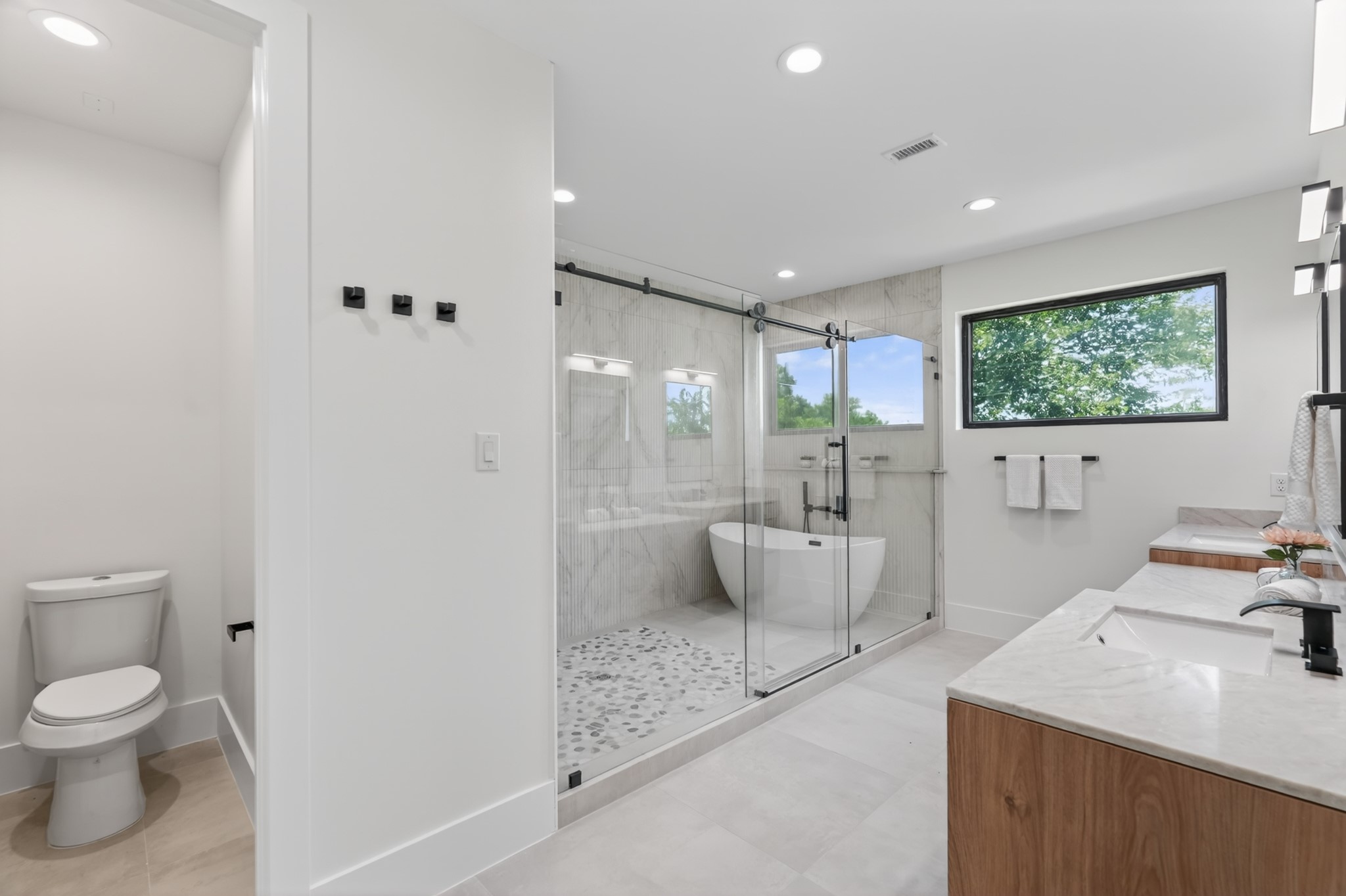 Elegant primary bath designed for everyday luxury with separate his-and-hers vanities, a dedicated makeup vanity, a spacious walk-in shower, a relaxing soaking tub, and an abundance of natural light.