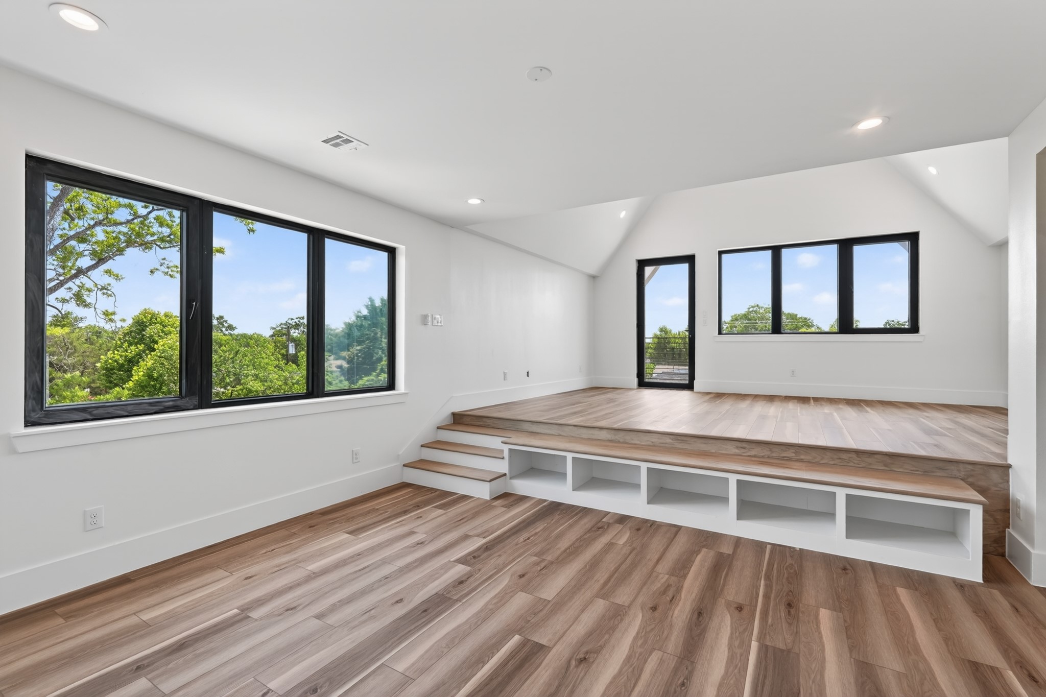 Unique primary suite occupying the entire third floor, featuring a split-level design with endless possibilities for a bedroom, private lounge, home theater, office, or fitness space. Filled with natural light and offering direct access to a private balcony.