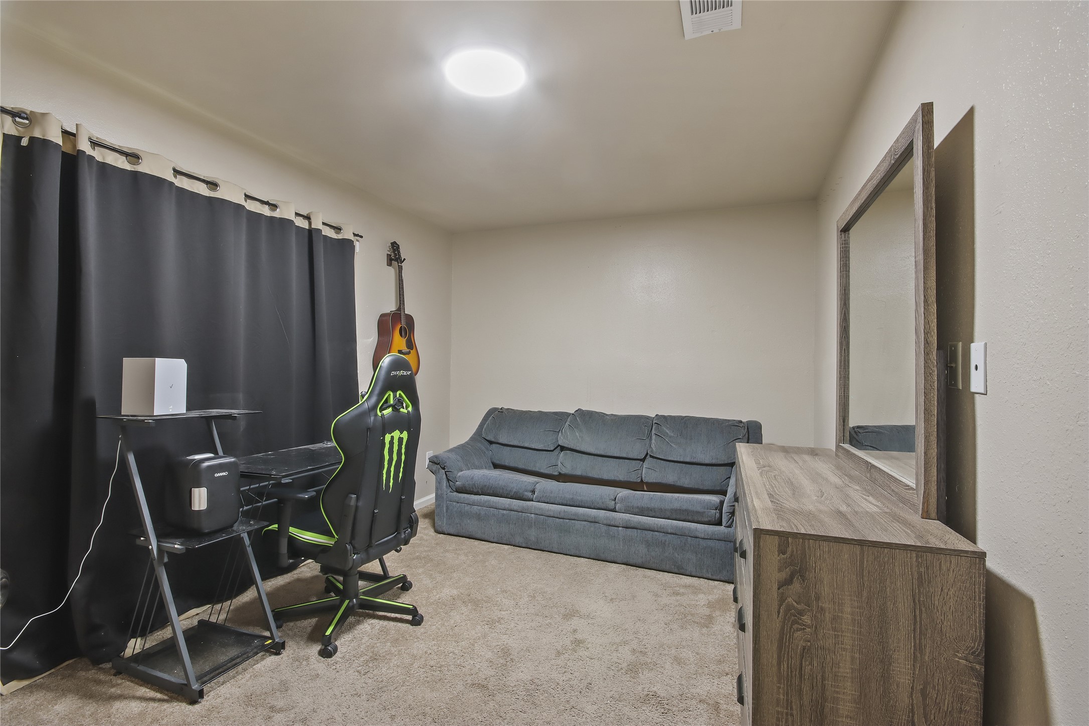 A second secondary bedroom offers carpet flooring and a window for natural light.