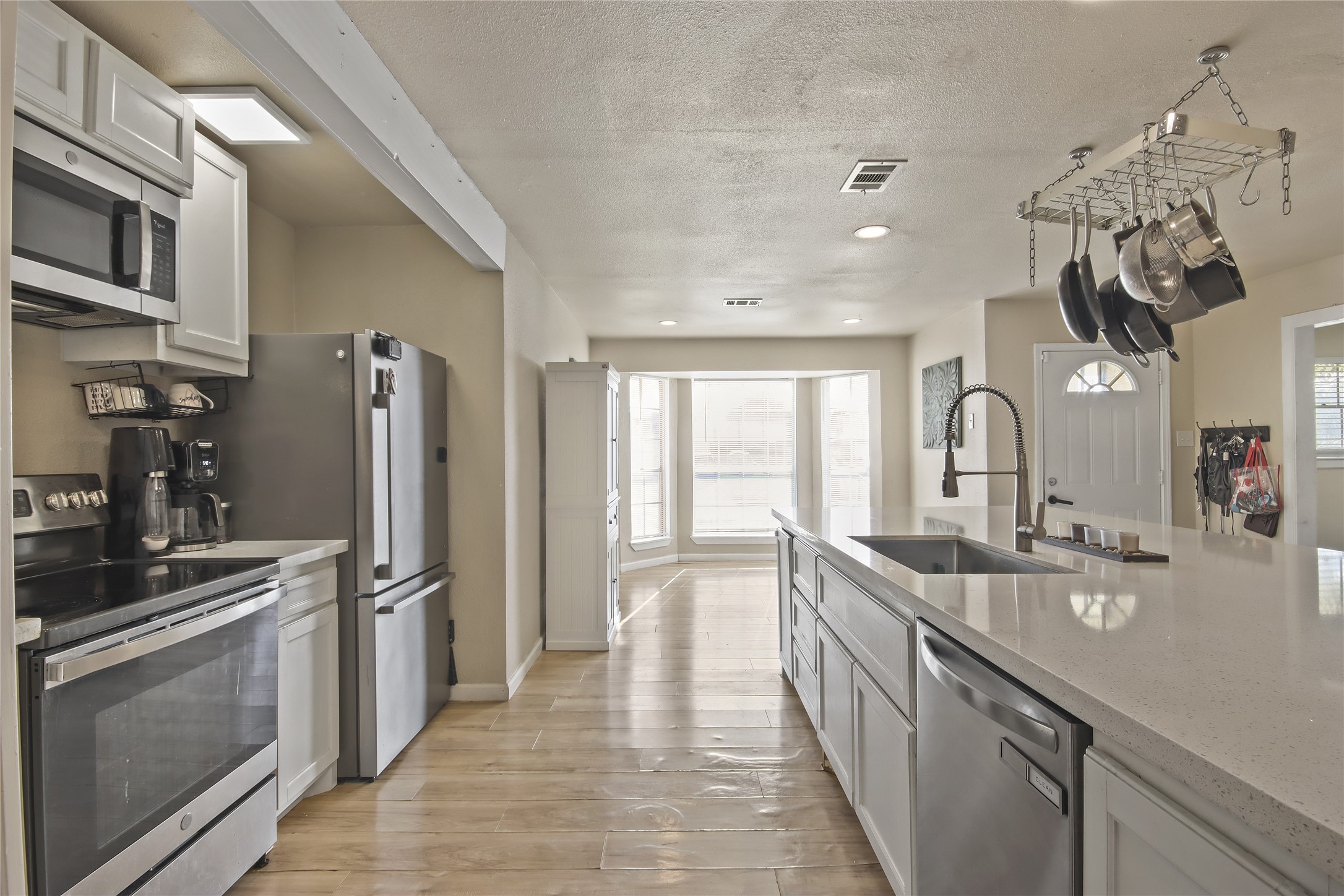 High end appliances and a lot of counter space complete the kitchen, with a pass-through view to the sunlit breakfast nook.