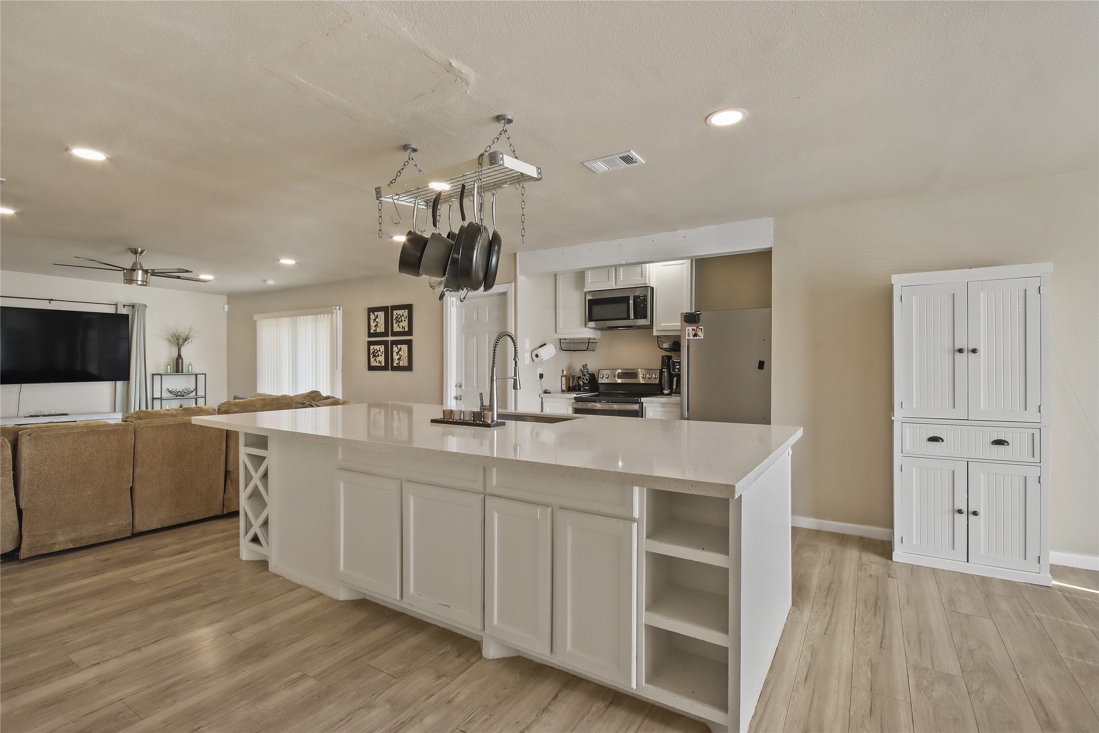 The kitchen island includes a built-in sink, providing extra workspace for meal prep and entertaining.