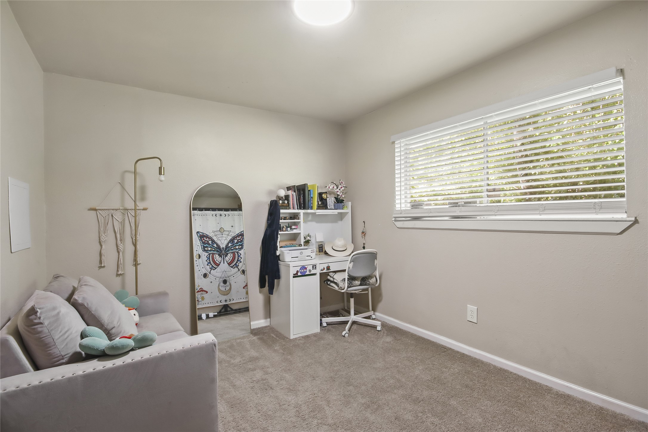 This secondary bedroom offers plush carpet and a large window with plenty of natural light.