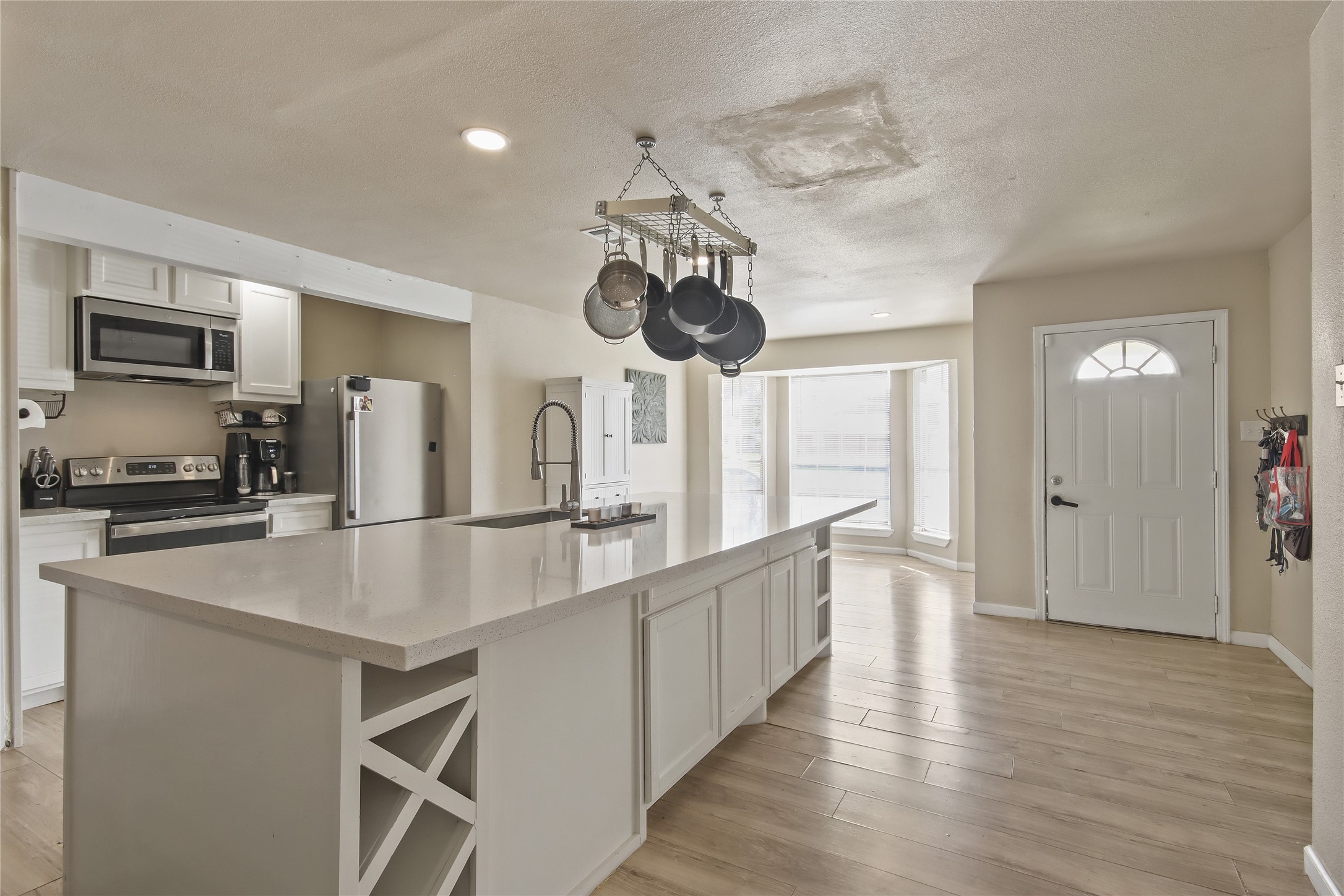 The kitchen offers a spacious island with durable counters and breakfast bar seating, opening directly to the living area.