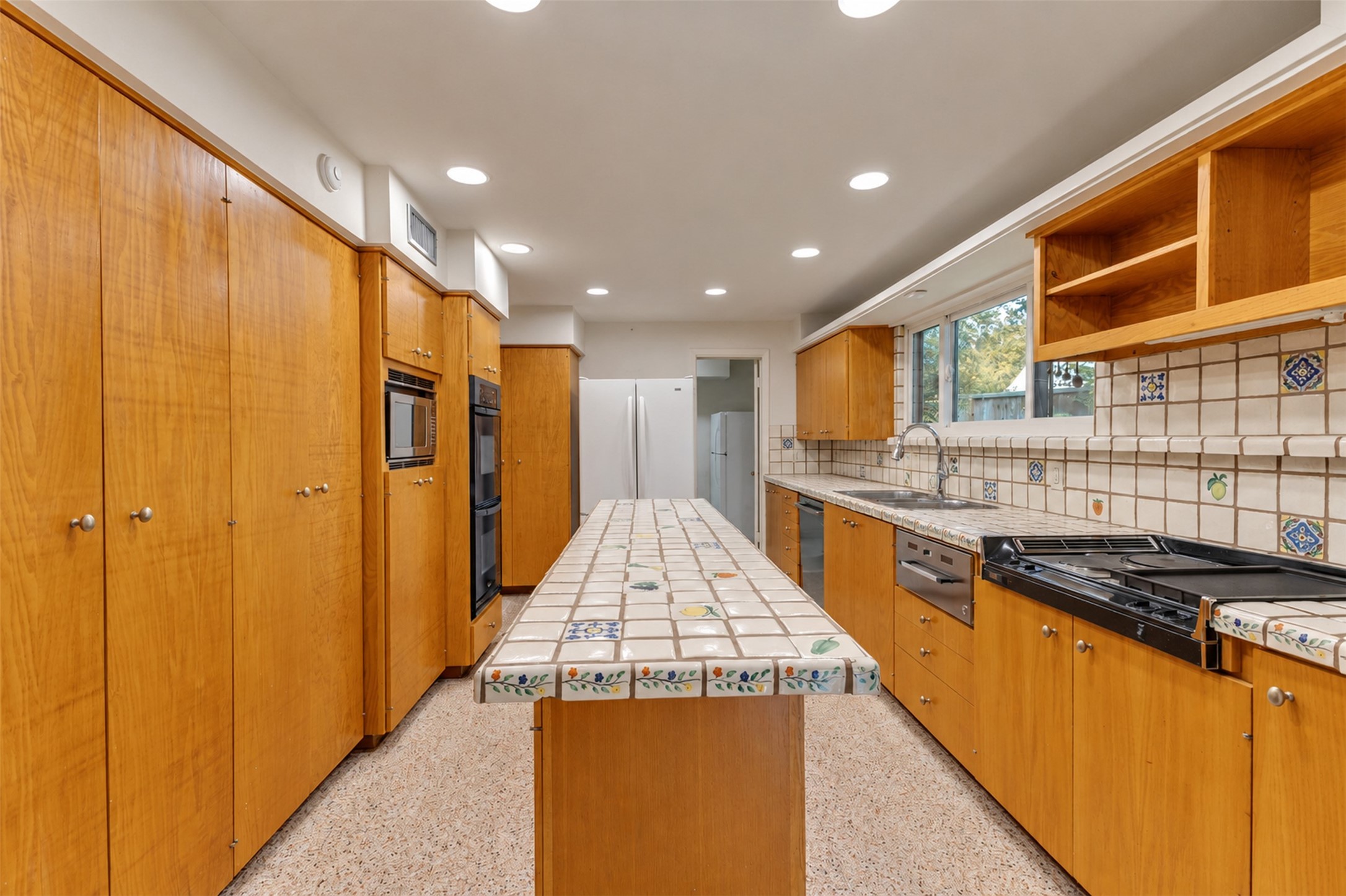 The kitchen has terrazzo floors and loads of storage.