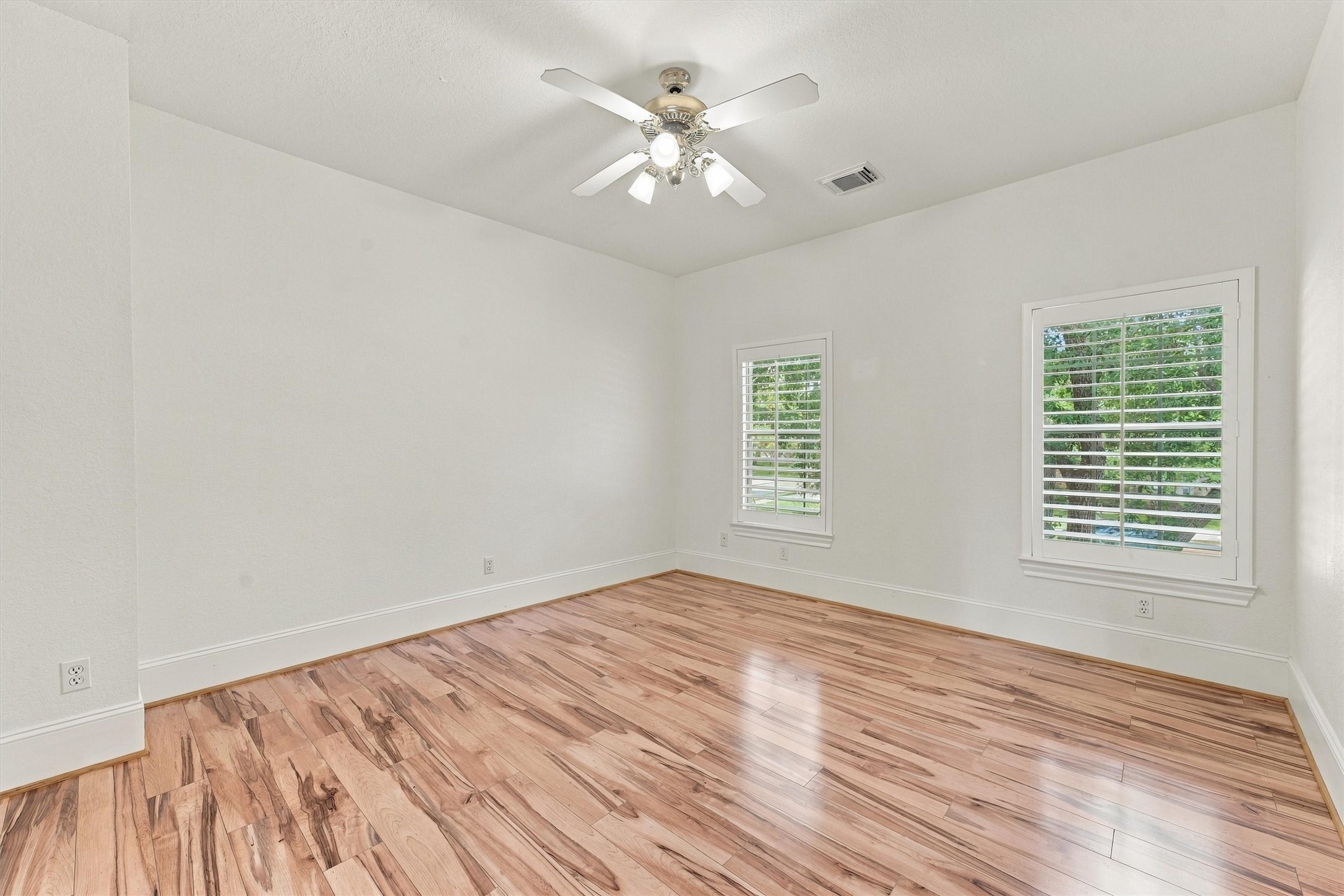 Second floor - Fouth Bedroom with ceiling fan, wood flooring, and two windows with plenty of natural light.
