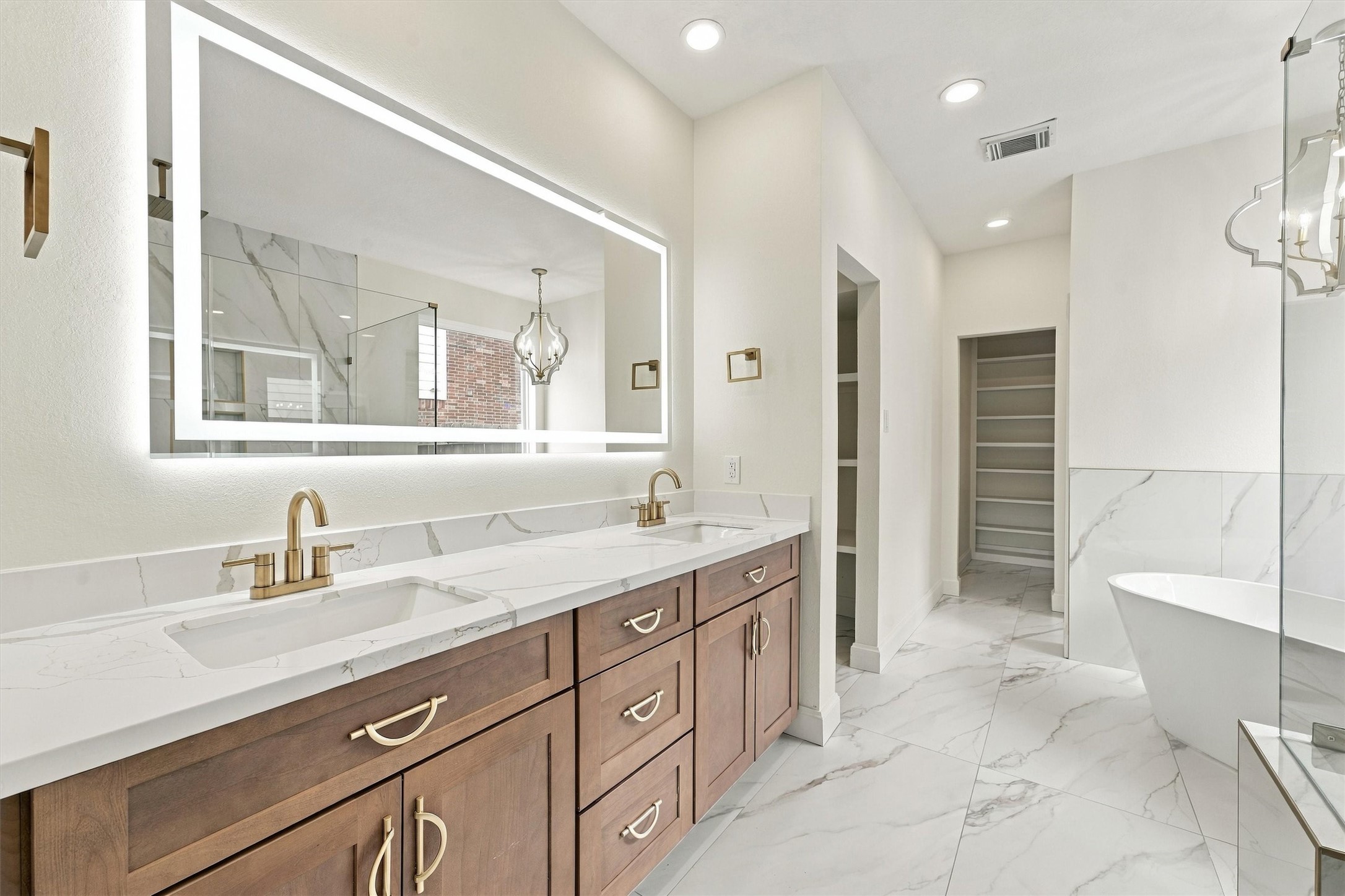 Primary bath - features white and gold marble tile with gold fixtures