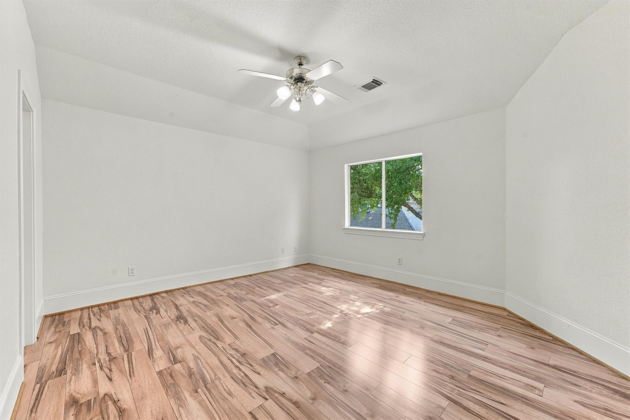 Upstairs second bedroom with ceiling fan and wood floors.