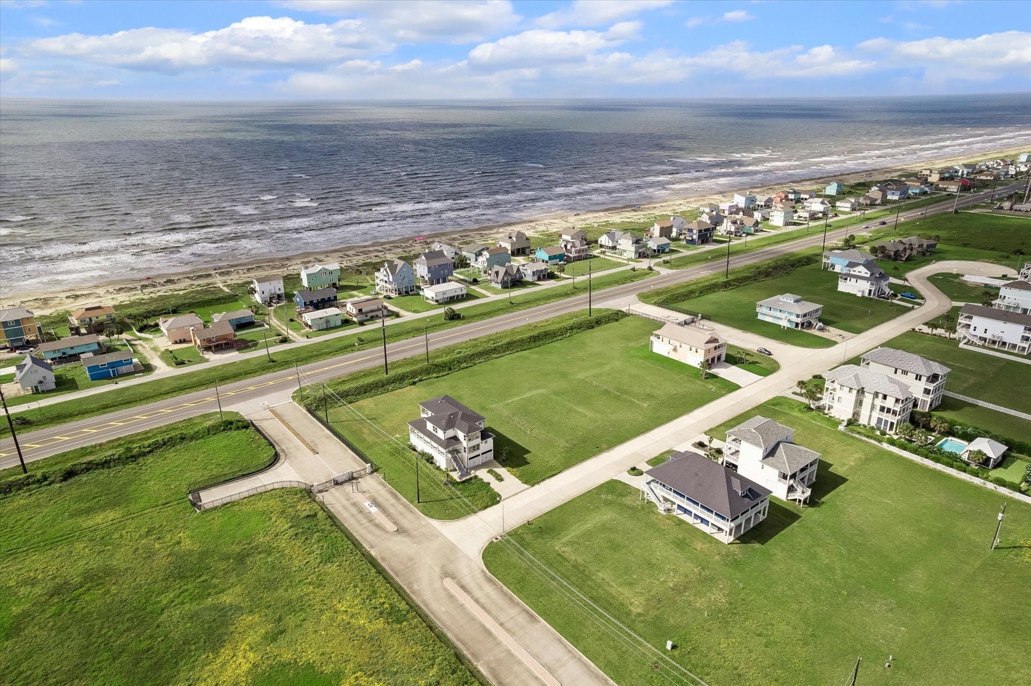Sunset Cove unfolds toward the shoreline in this sweeping view, with the beach an easy reach from your front door.