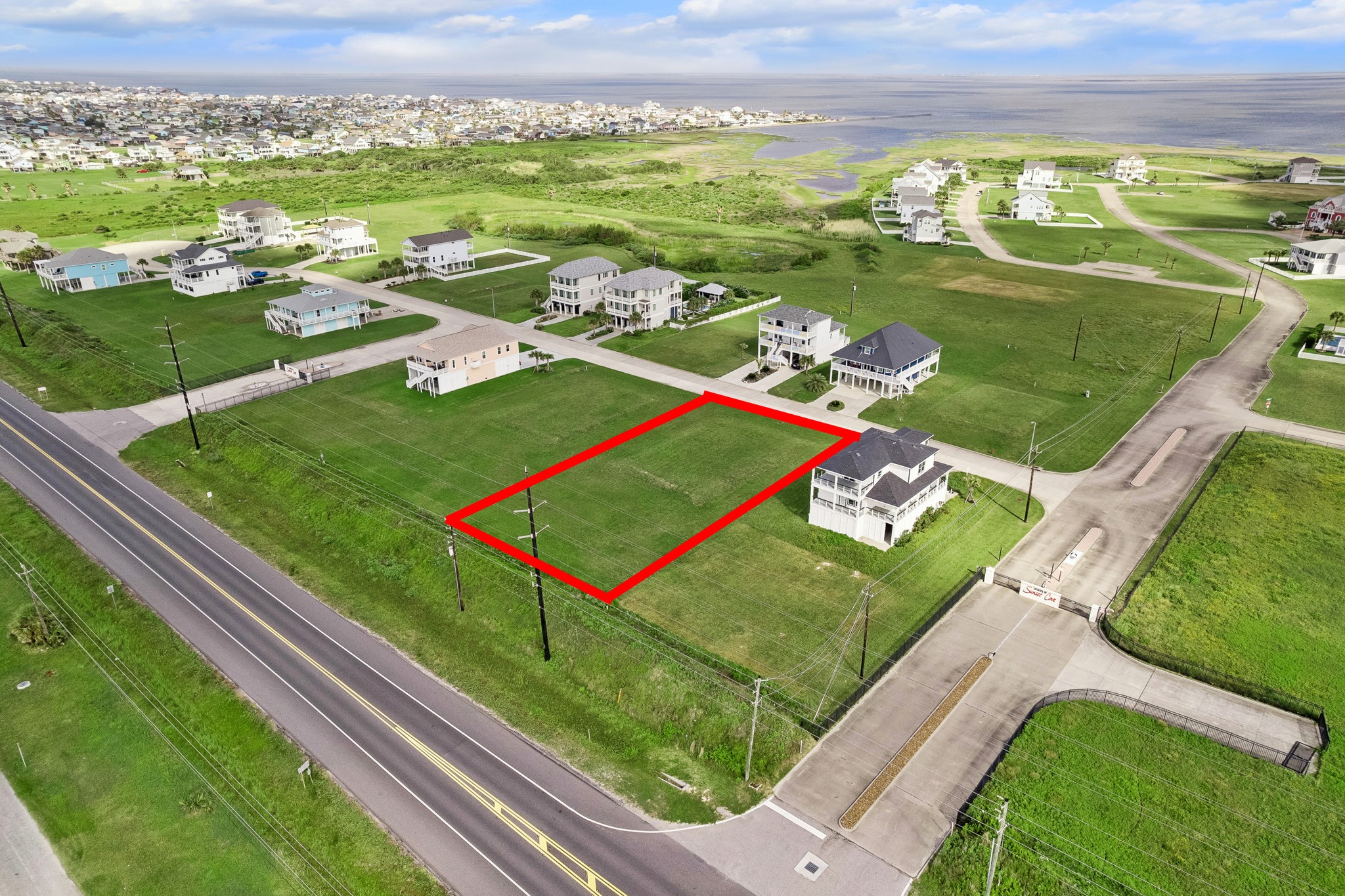 Gated entry into Sunset Cove leads to paved community streets that run right to the property line, creating a clean approach for a future driveway and build site.