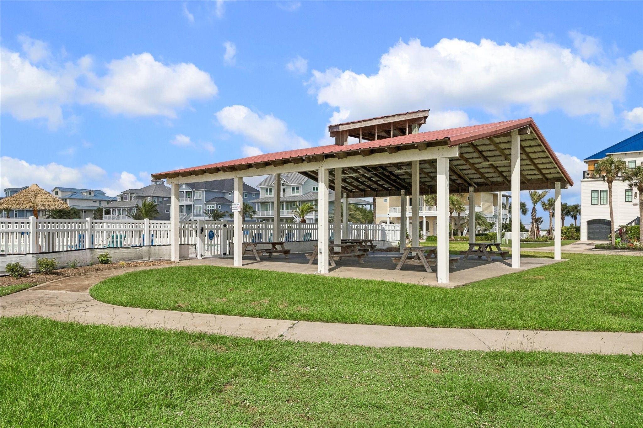 A covered pavilion shaded by a timber-trussed roof invites cookouts and shaded afternoons by the water.
