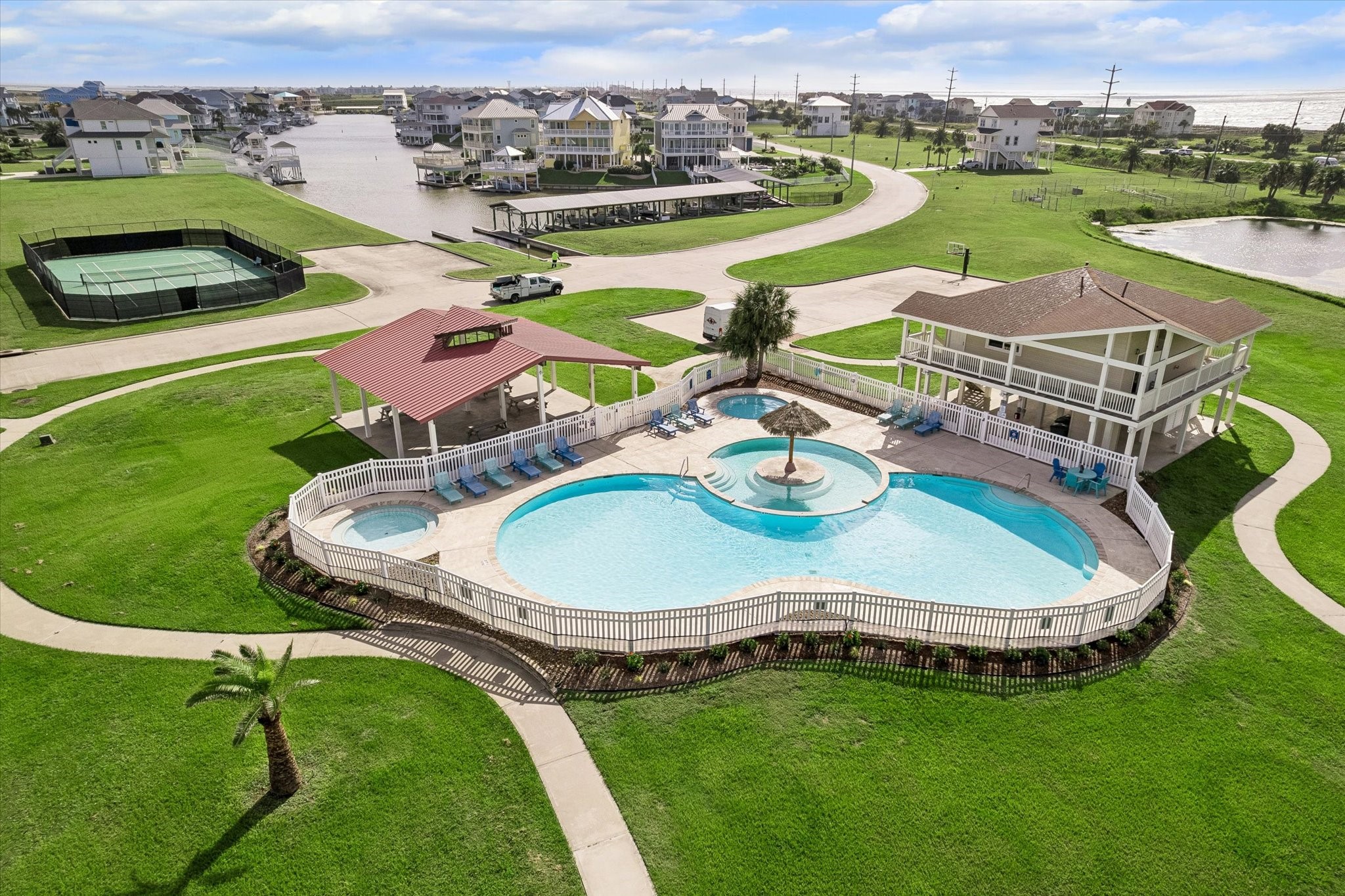 Residents gather at the community pool and clubhouse, where well kept lawns wrap a resort-style retreat.