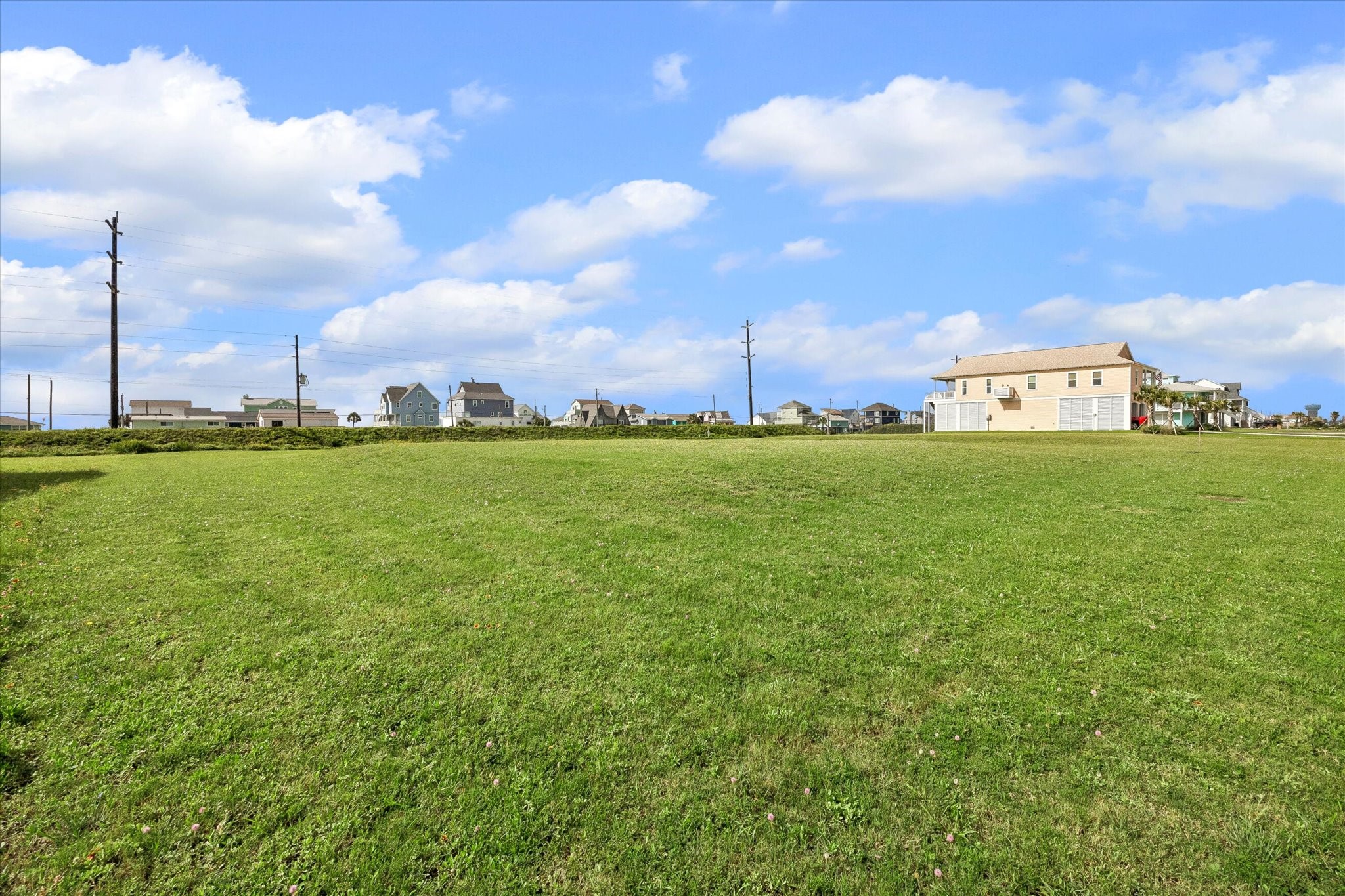 Open sky and salt air greet you across the lot, with power already running along the street.