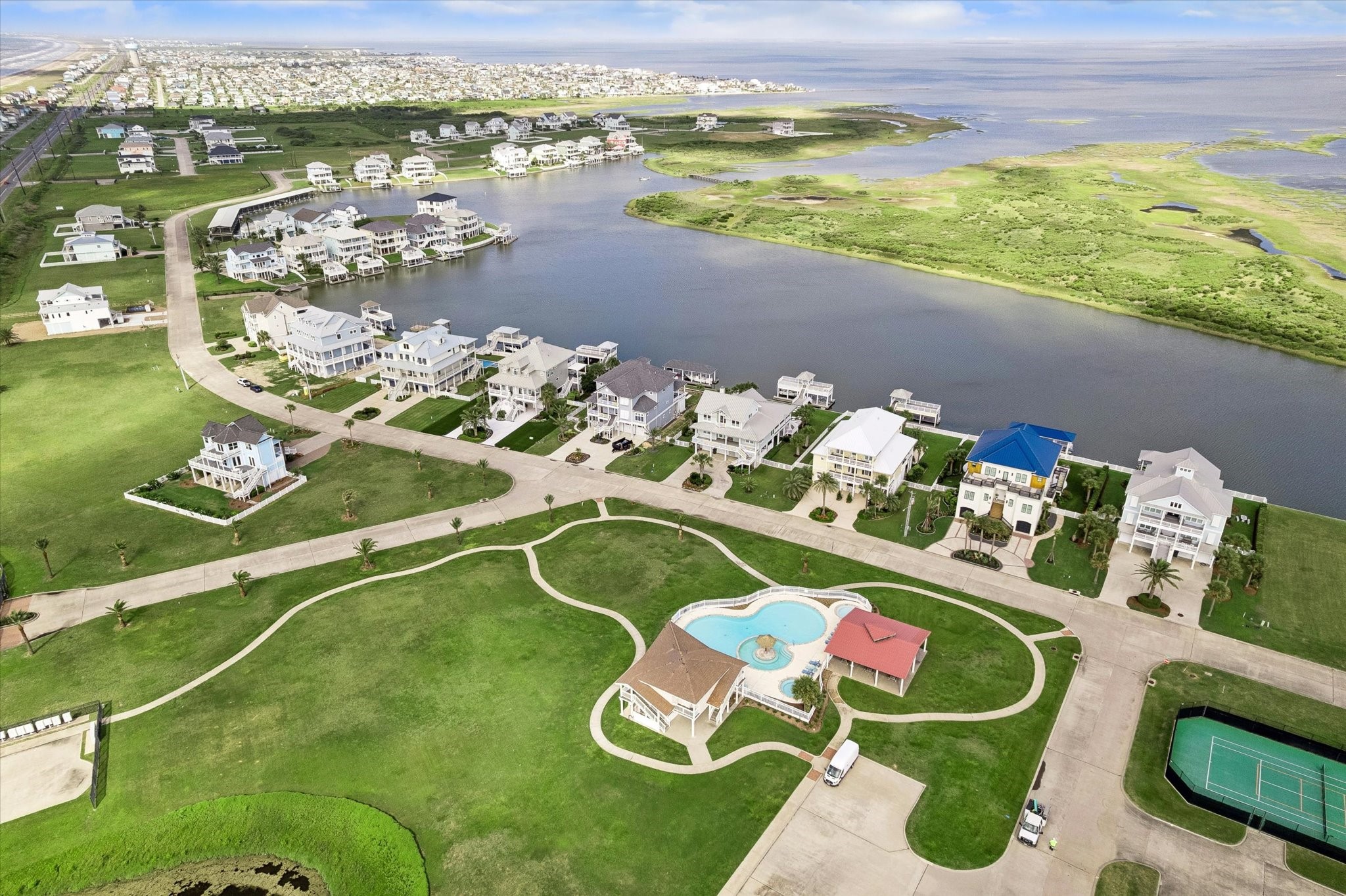 Neighborhood amenities sit just inside Sunset Cove, with a community pool, tennis court, and wide green spaces set along the water. A quiet coastal setting with room to enjoy the outdoors beyond your own future homesite.