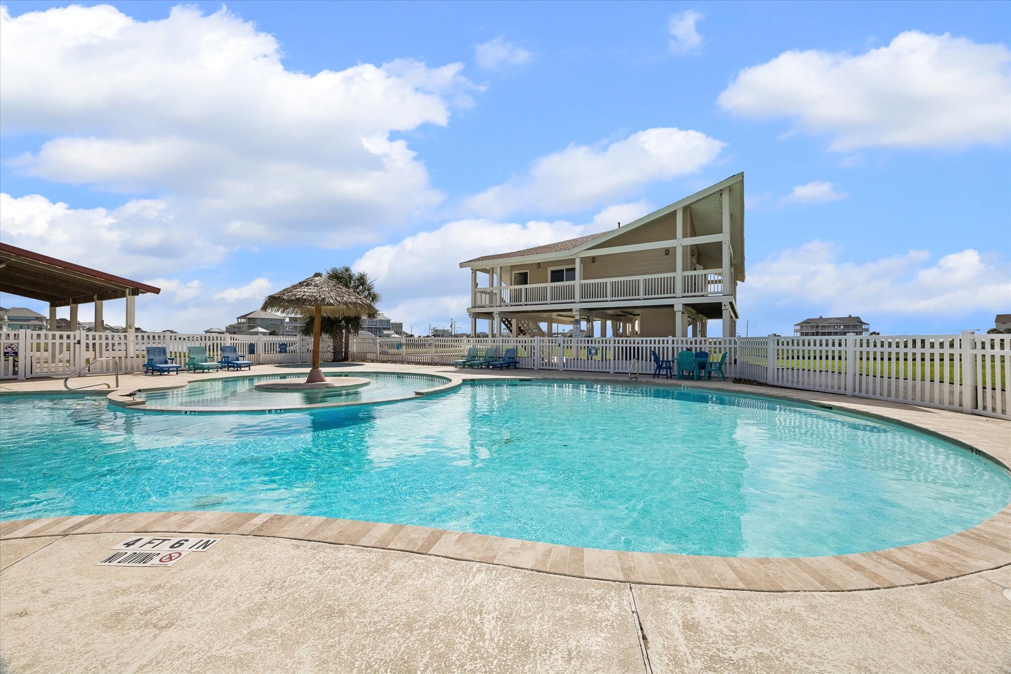 Another view of the Sunset Cove pool highlights the laid-back coastal setting, with shaded seating and open-air gathering areas nearby. Resort-style amenities add an easy lifestyle element just moments from the homesite.