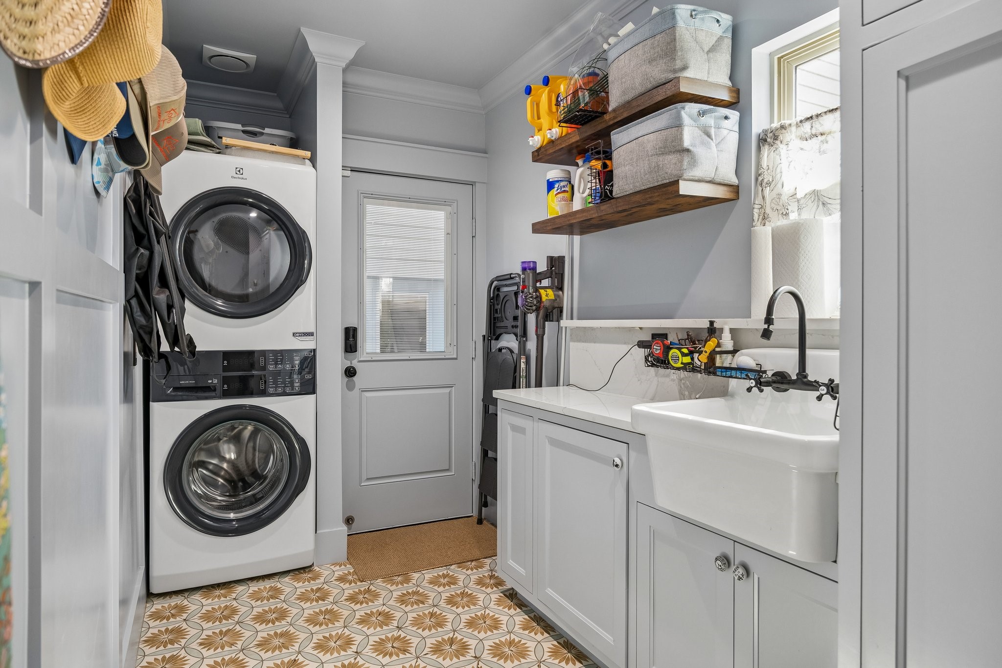 Established mudroom with sink and overhead storage.