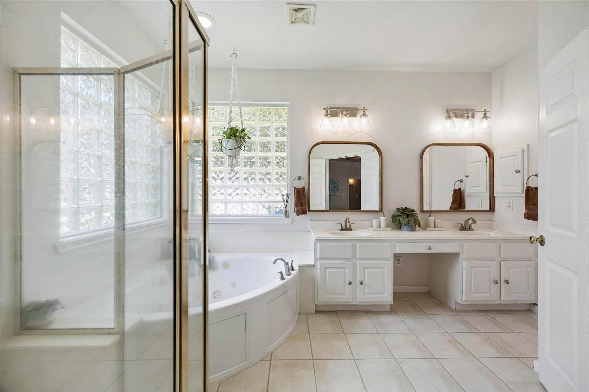 Primary en-suite bathroom features a double vanity, soaking tub and a glass enclosed walk-in shower.