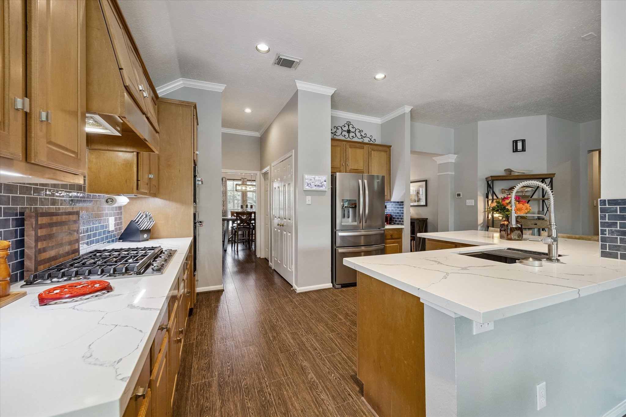 Another view of the kitchen leading to the pantry, half bath, walk-in utility room and formal dining area. Notice the crown molding flowing throughout the home.
