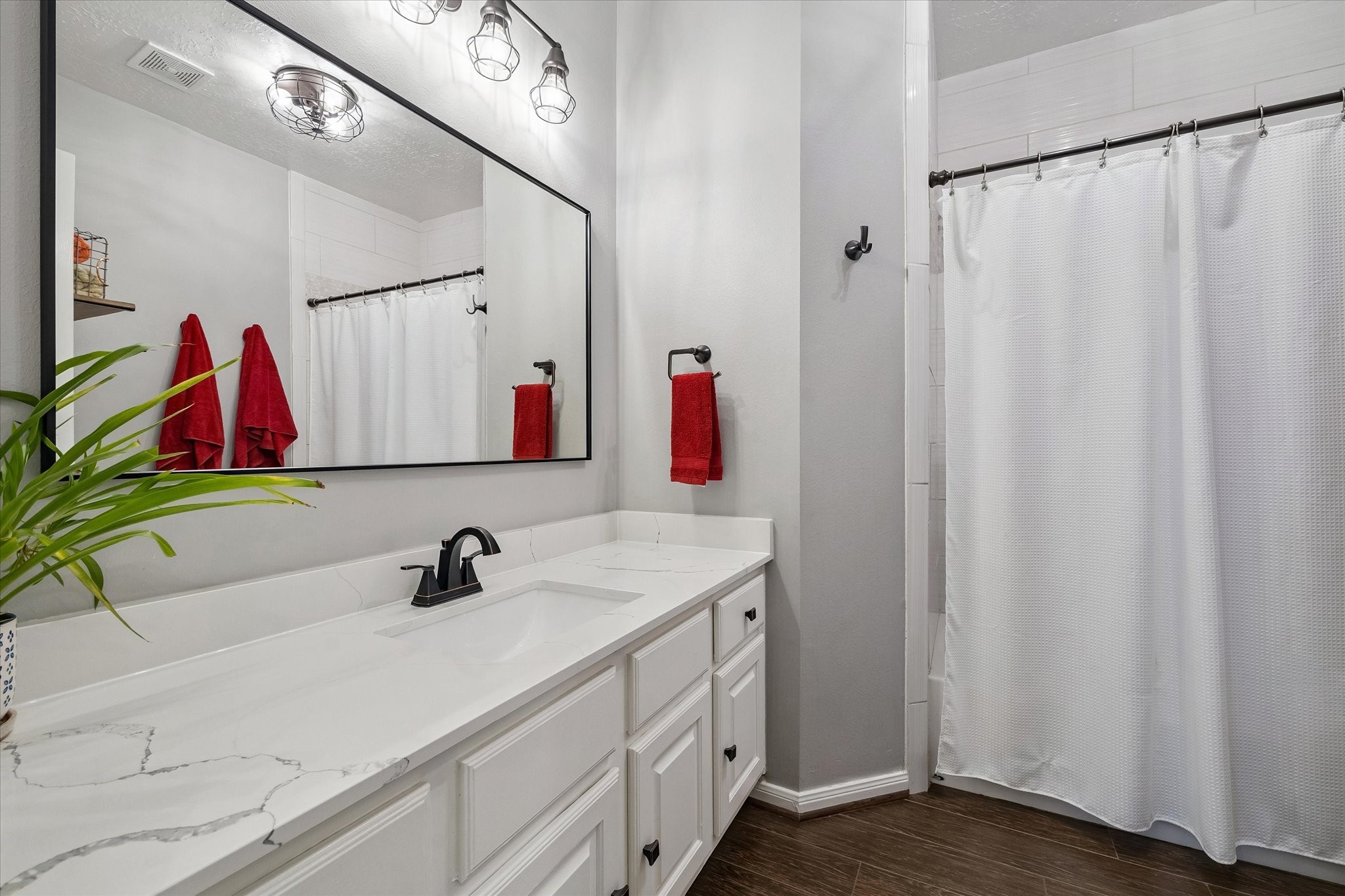 The guest bathroom includes a tub-shower combo, a quartz countertop and plenty of space.