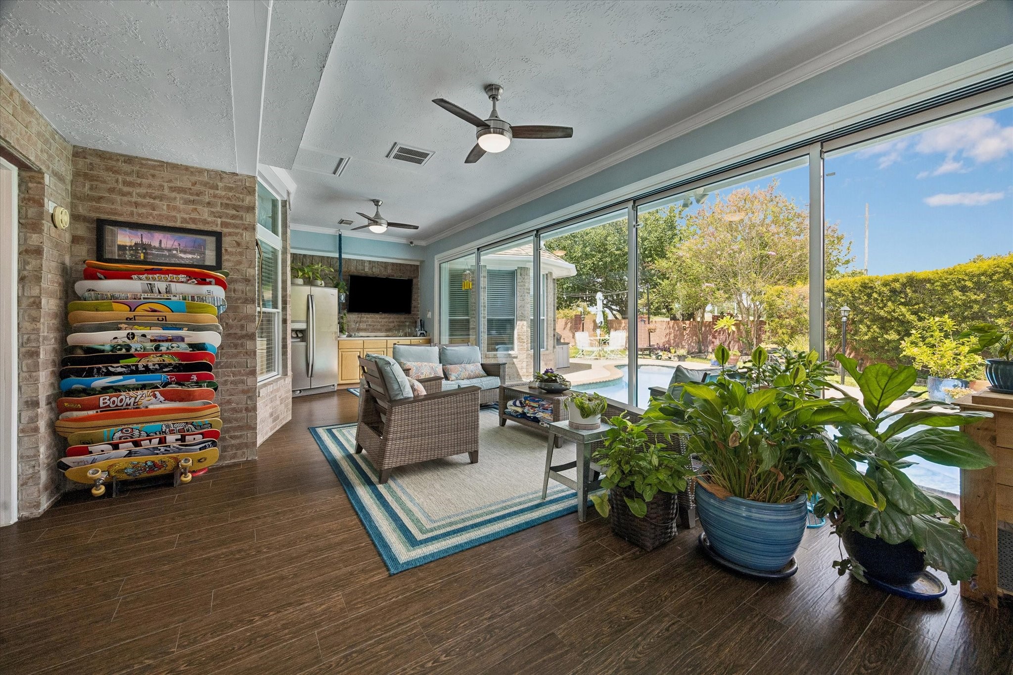 The sunroom features a CUSTOM SLIDING GLASS WALL that transforms the space into an open concept directly to the backyard. This space can also be used as a game room. Perfect for entertaining!
