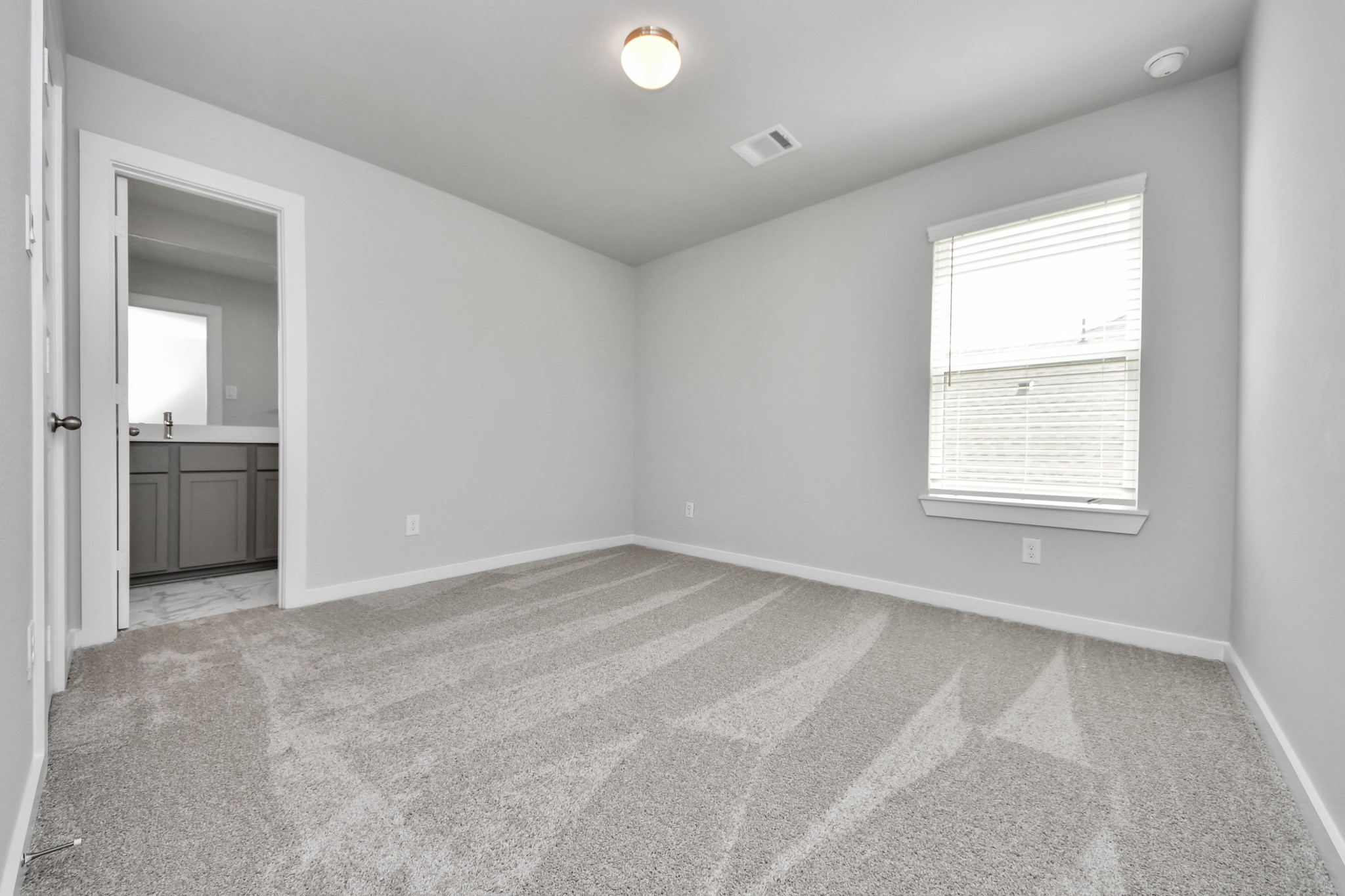 Secondary bedroom features plush carpeting, large windows that let in plenty of natural light, bright paint, and spacious closets. Sample photo of completed home with similar floor plan. Actual colors and selections may vary.