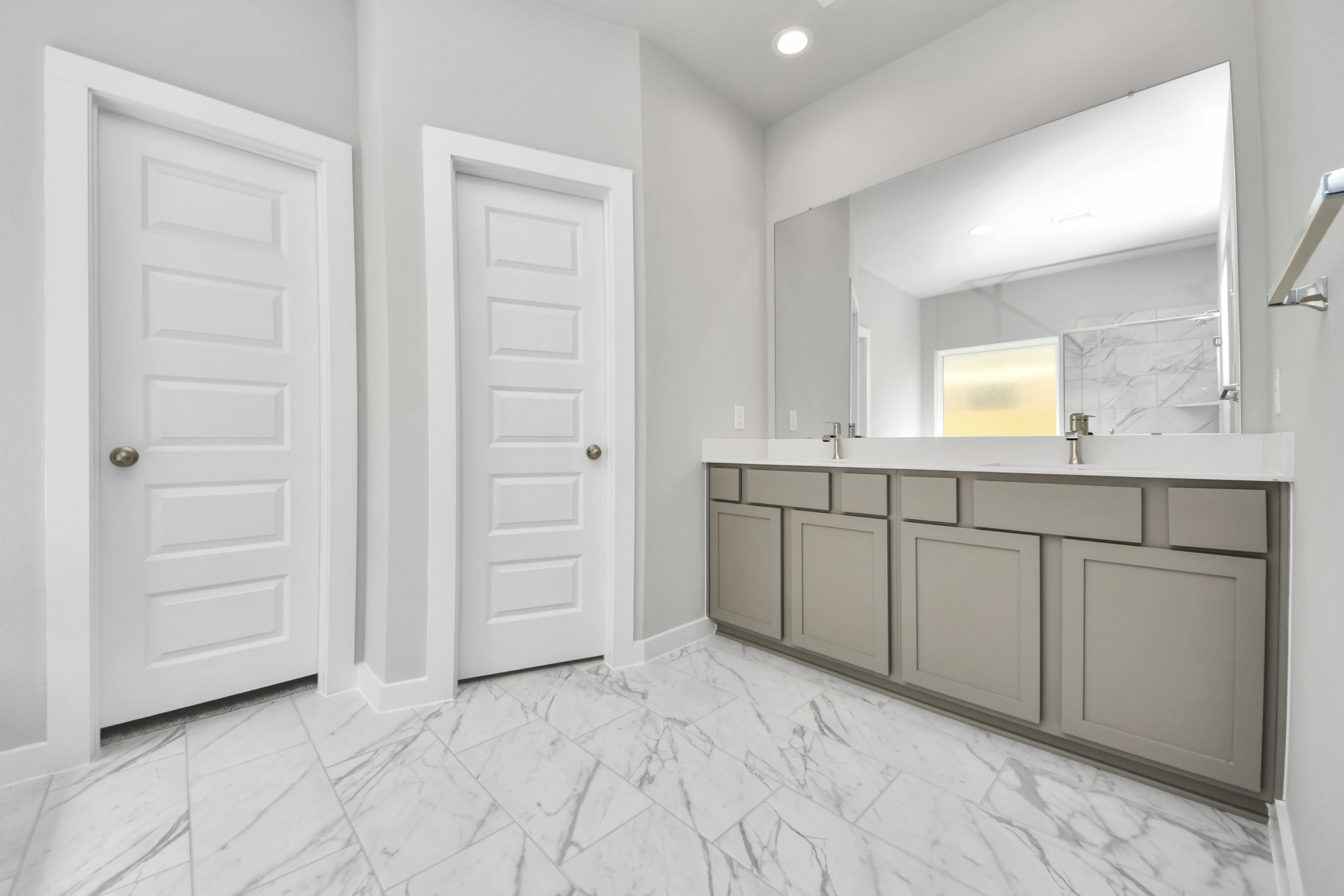 Elevate your daily routine at the elegant vanity, now equipped with double sinks, light countertops, modern hardware, and beautiful recessed lights. Sample photo of completed home with similar floor plan. Actual colors and selections may vary.