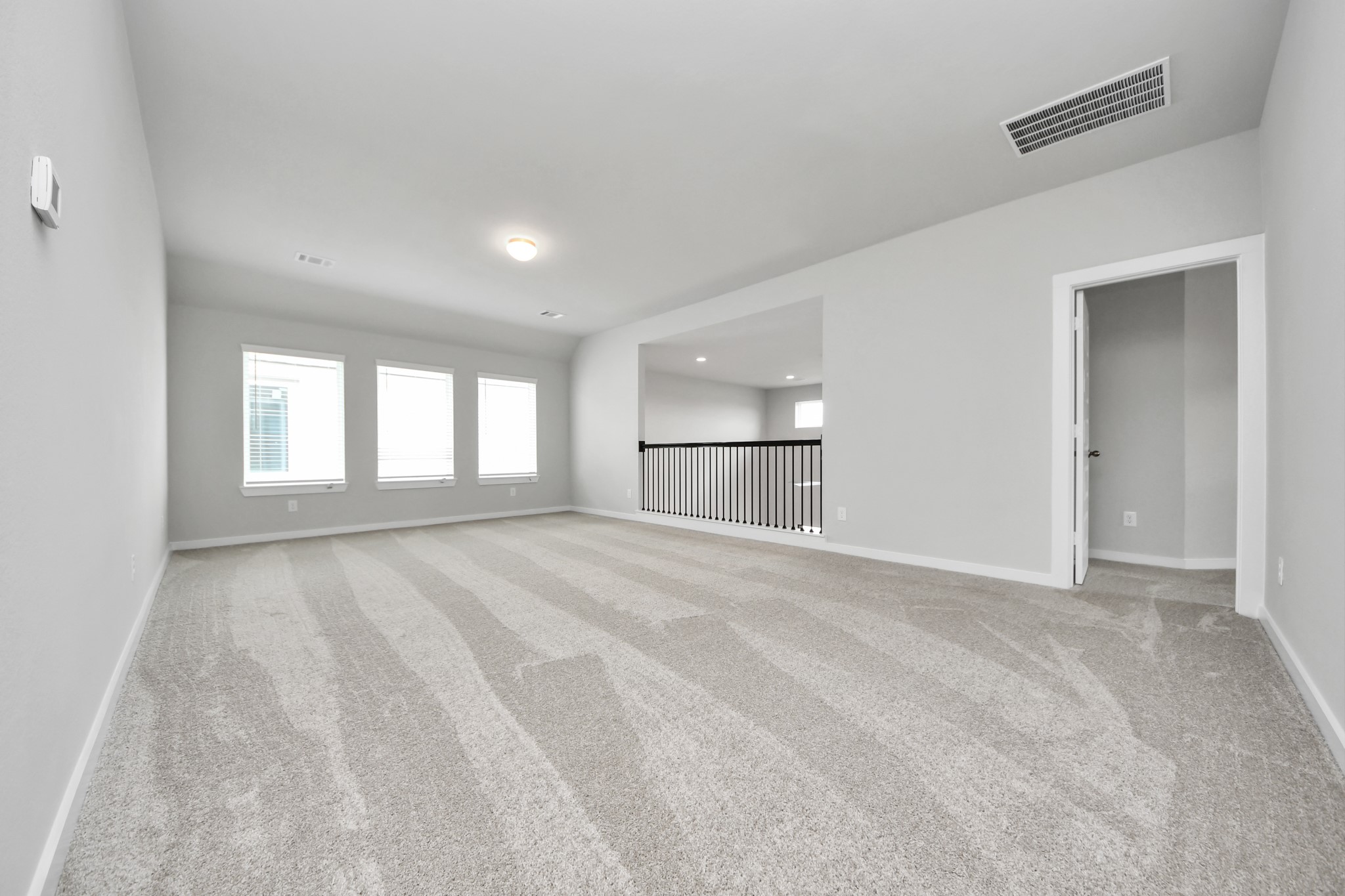 Come upstairs and enjoy a day of leisure in this fabulous game room! This is the perfect hangout spot or adult game room! Features plush carpet, high ceilings, custom paint and windows for plenty of natural light. Sample photo of completed home with similar floor plan. Actual colors and selections may vary.