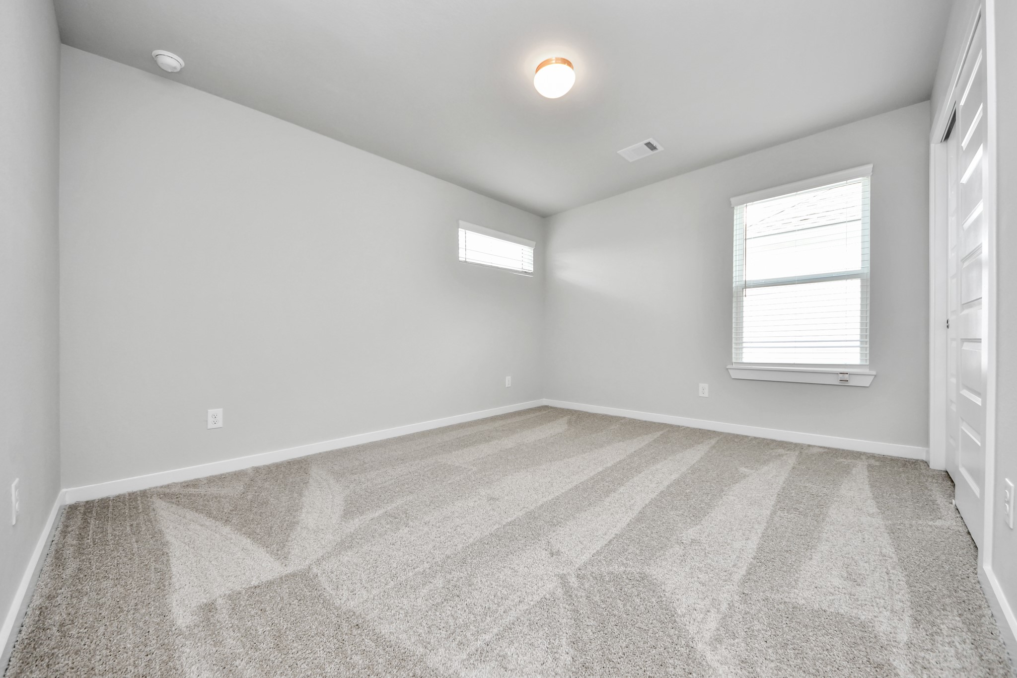 Generously sized secondary bedrooms featuring spacious closets, soft and inviting carpeting underfoot, large windows allowing plenty of natural light, and the added touch of privacy blinds for your personal retreat. Sample photo of completed home with similar floor plan. Actual colors and selections may vary.